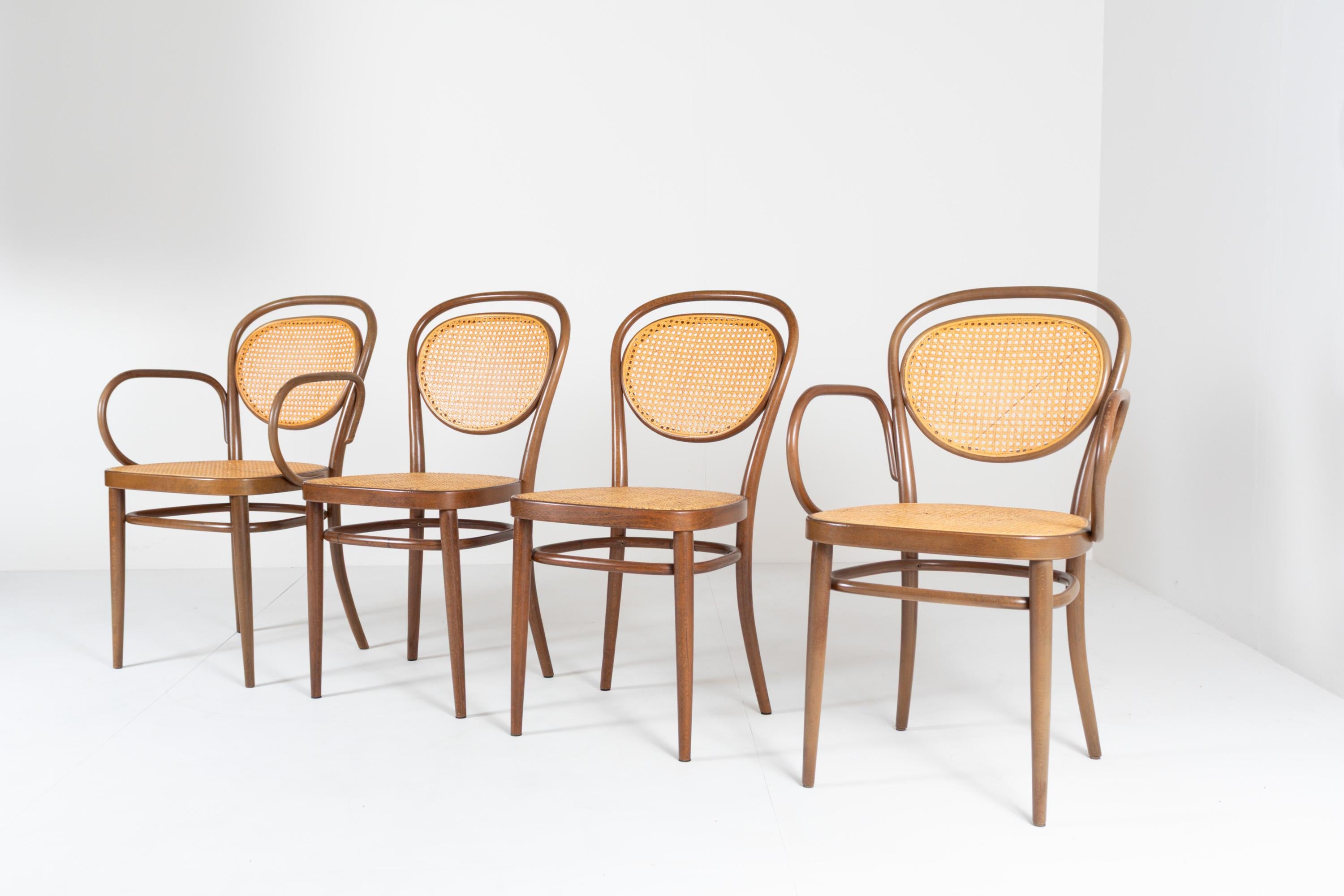 Set di 4 sedie vintage Thonet degli anni '70, realizzate in Germania. Questo set comprende 2 sedie Thonet 215 RF con braccioli e 2 sedie Thonet 215 senza braccioli. Il design, creato da Michael Thonet nel 1859, è iconico per la sua eleganza e