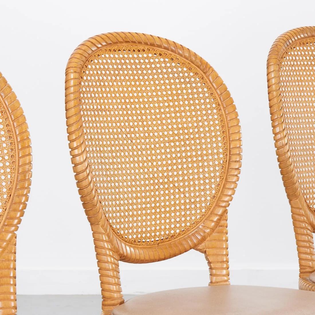 Satz von vier Ballonstühlen mit Rohrrücken.  Die Rahmen der Stühle sind aus geschnitztem Holz und die Sitze mit Vinyl bezogen.  