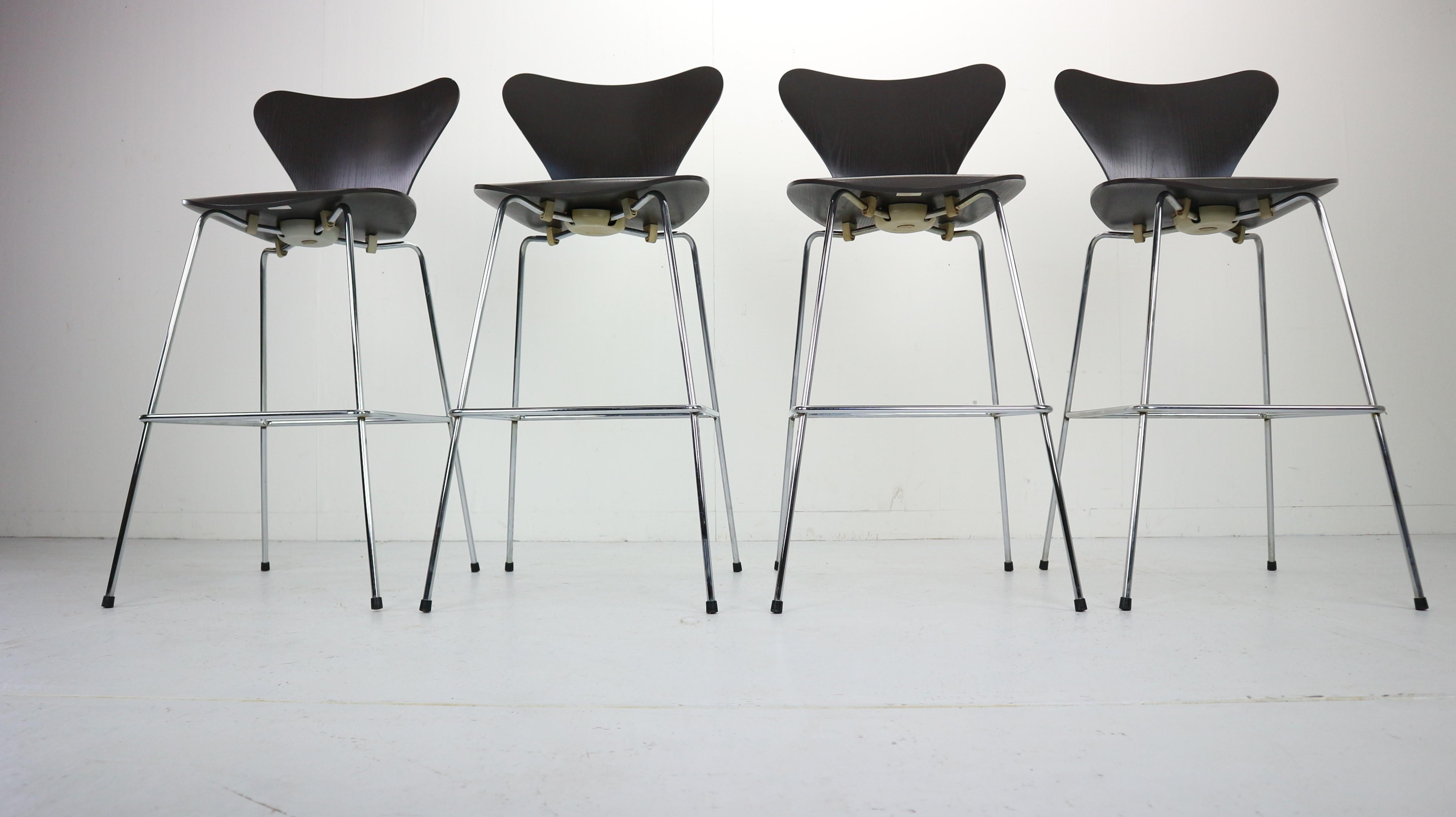 Set of 4 bar stools, all originally marked by Arne Jacobsen for Fritz Hansen manufacture 1950's, Denmark.
Made of black wood veneer and polychromed steel.
Seating comfort and can be combined with different bases for a range of dining chairs,