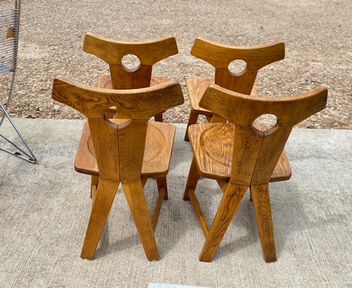 Set of 4 brutalist solid oak chairs, Belgium, circa 1960s features unique curved back, seats have a beveled indention, sturdy and in good overall condition with light age-appropriate wear. 
Dimensions: 18