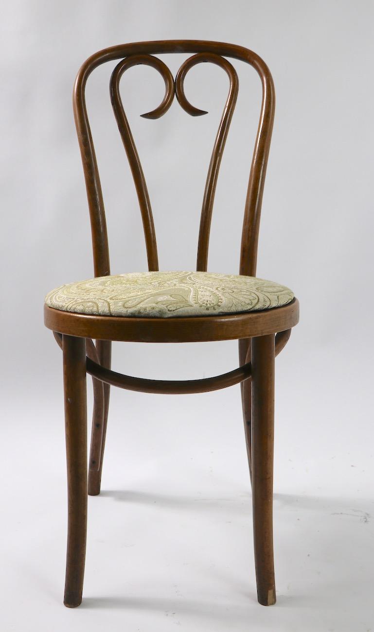 Bel ensemble de 2 chaises de salle à manger, ou de café, en bois courbé et tapissé, attribué à Thonet. Propre et prêt à l'emploi, les sièges sont recouverts d'une sellerie vinyle plus récente. Pas de cassures ni de dommages structurels, à noter -  