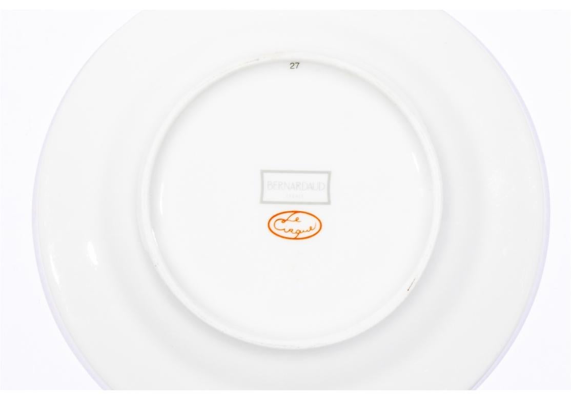 Ensemble de quatre assiettes à pain et à beurre ou assiettes à gâteau en porcelaine de Bernardaud Limoges pour Le Cirque, présentant une bordure vert vif avec des images de singes cueillant des fruits et une bordure orange. Fabriqué en France.

Ce