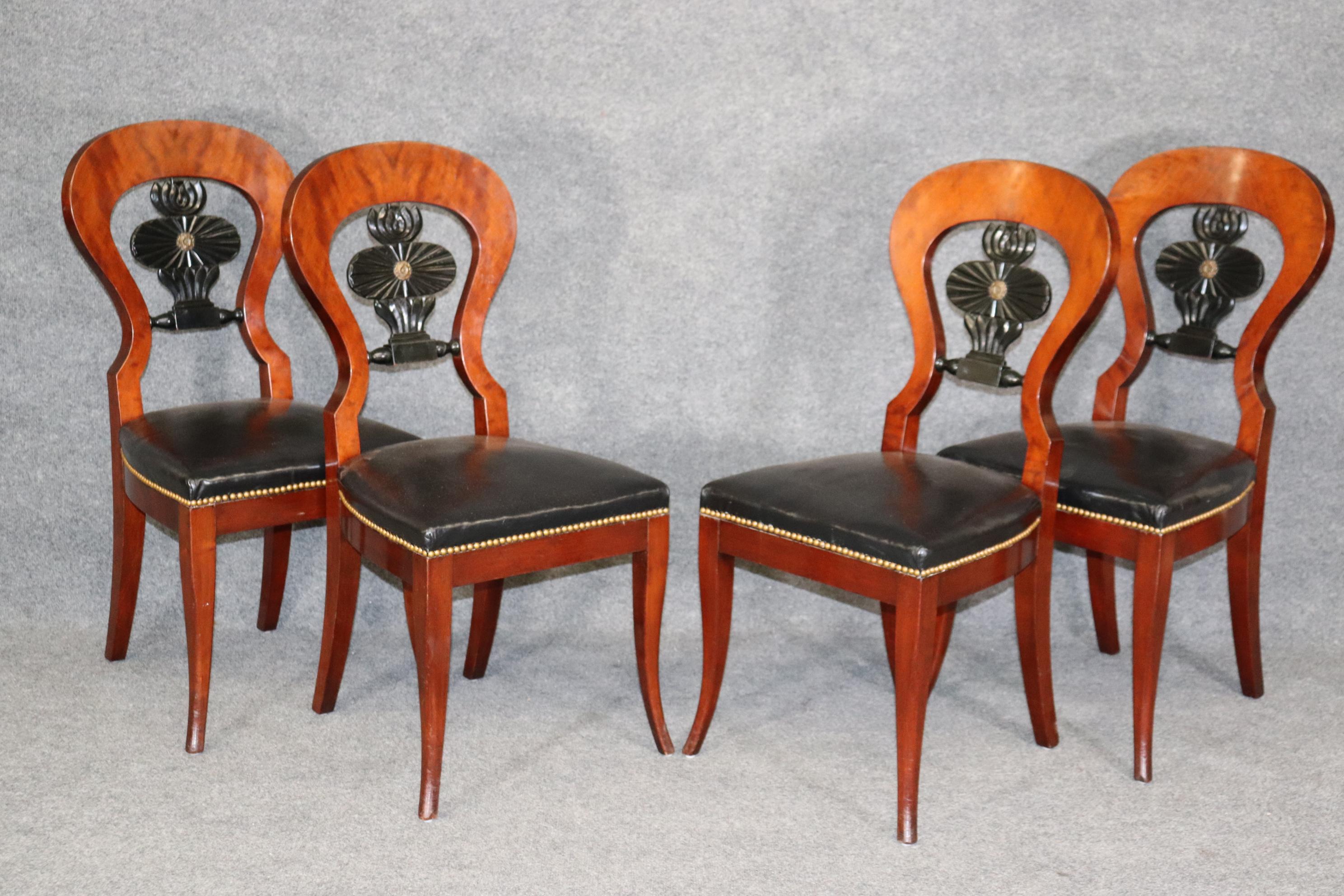 This is a gorgeous set of 4 Biedermeier style dining chairs with what appears to be black leather upholstery but I can't say for sure. The frames are beautiful rich walnut with small brass details. The chairs measure 36.75 tall x 17.25 wide x 20