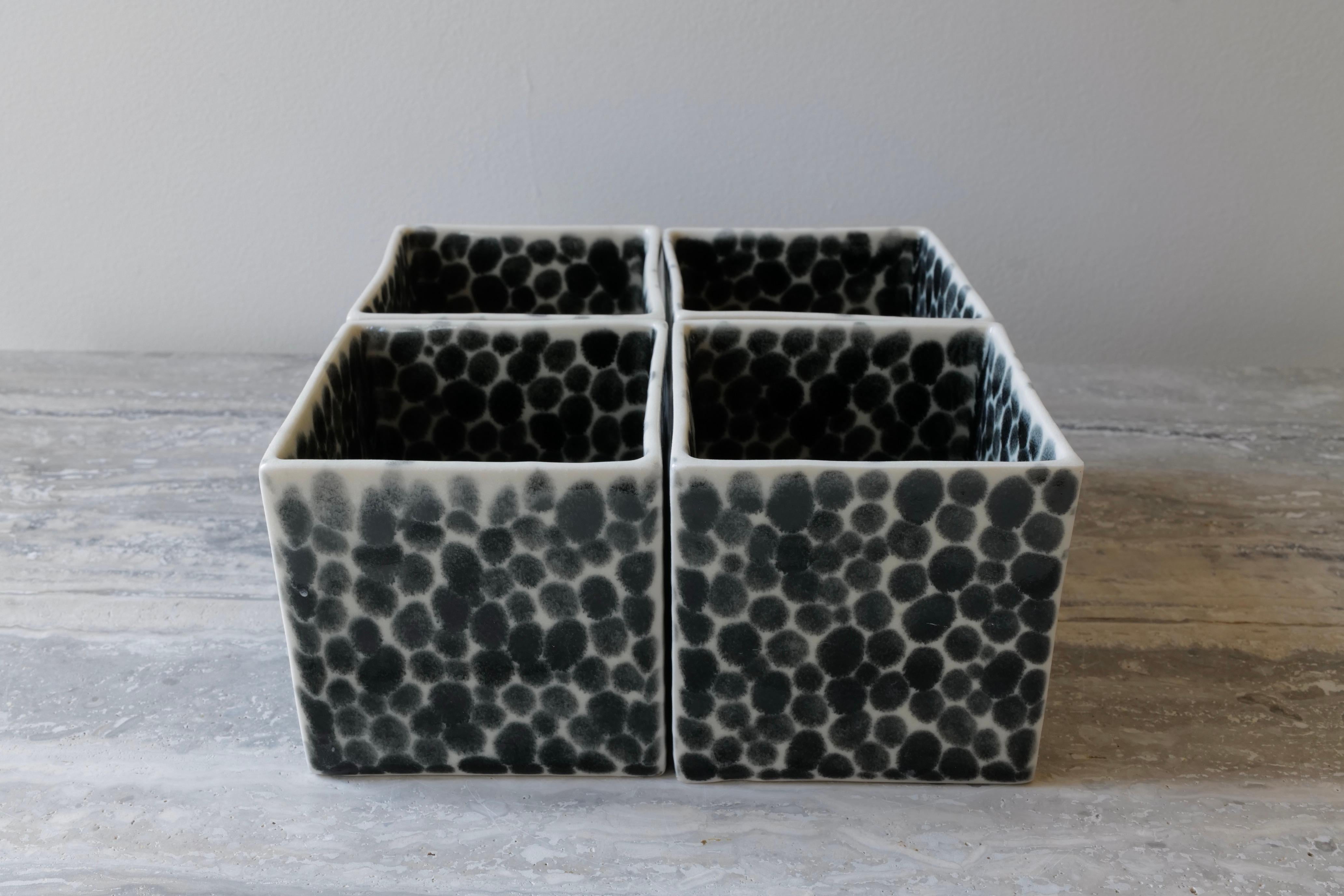 Set of 4 elegant open cubes, which function together as a sculpture or could be filled with cookies, nuts, tea bags or else. Hand-cast in porcelain and once bisque fired, each dot is hand-painted with shiny black glaze. An unconventional layered