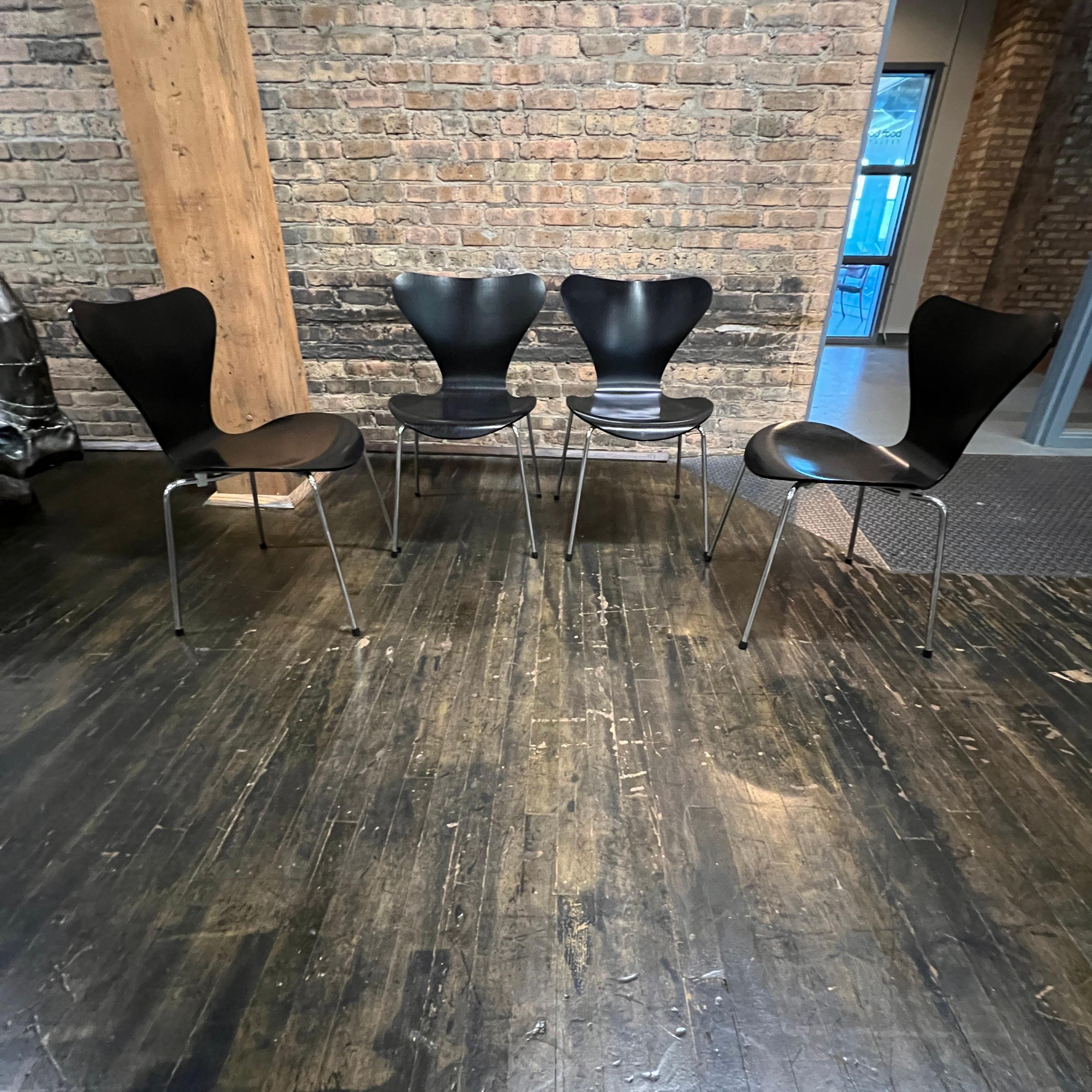 Il s'agit d'un ensemble de 4 chaises de la Série 7 (modèle 3107) par Arne Jacobsen pour Fritz Hansen.  Les sièges sont en placage de frêne coloré - noir (#195).  La chaise de la série 7 est une icône dans l'histoire du mobilier moderne.  Conçue à