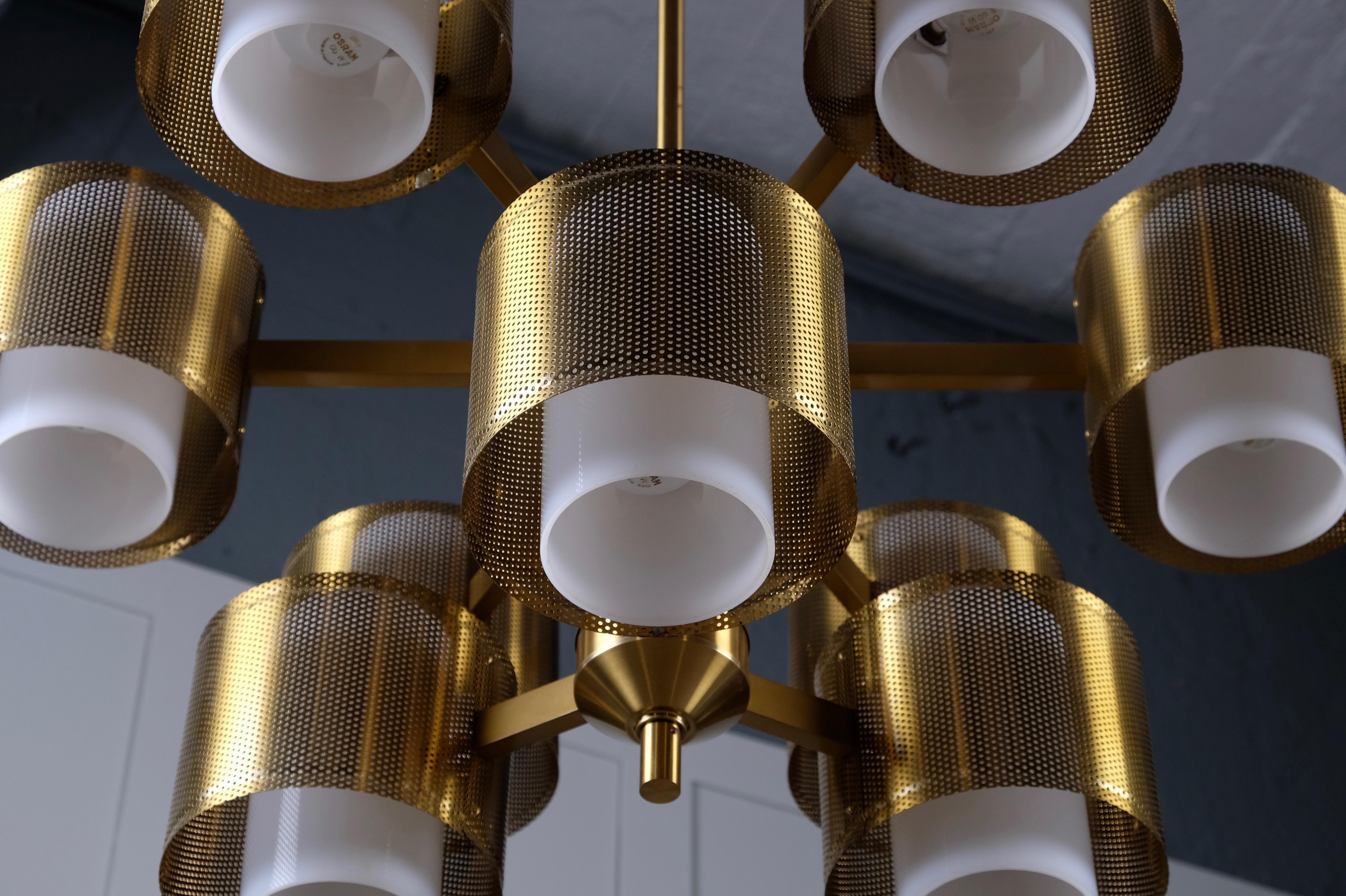 Rare model, produced in Sweden, 1960s. Perforated brass and acrylic shades.
Please note: height is adjustable after your preferences. 
Excellent vintage with small signs of usage and patina.
Listed price is for one (1) chandelier. 

 