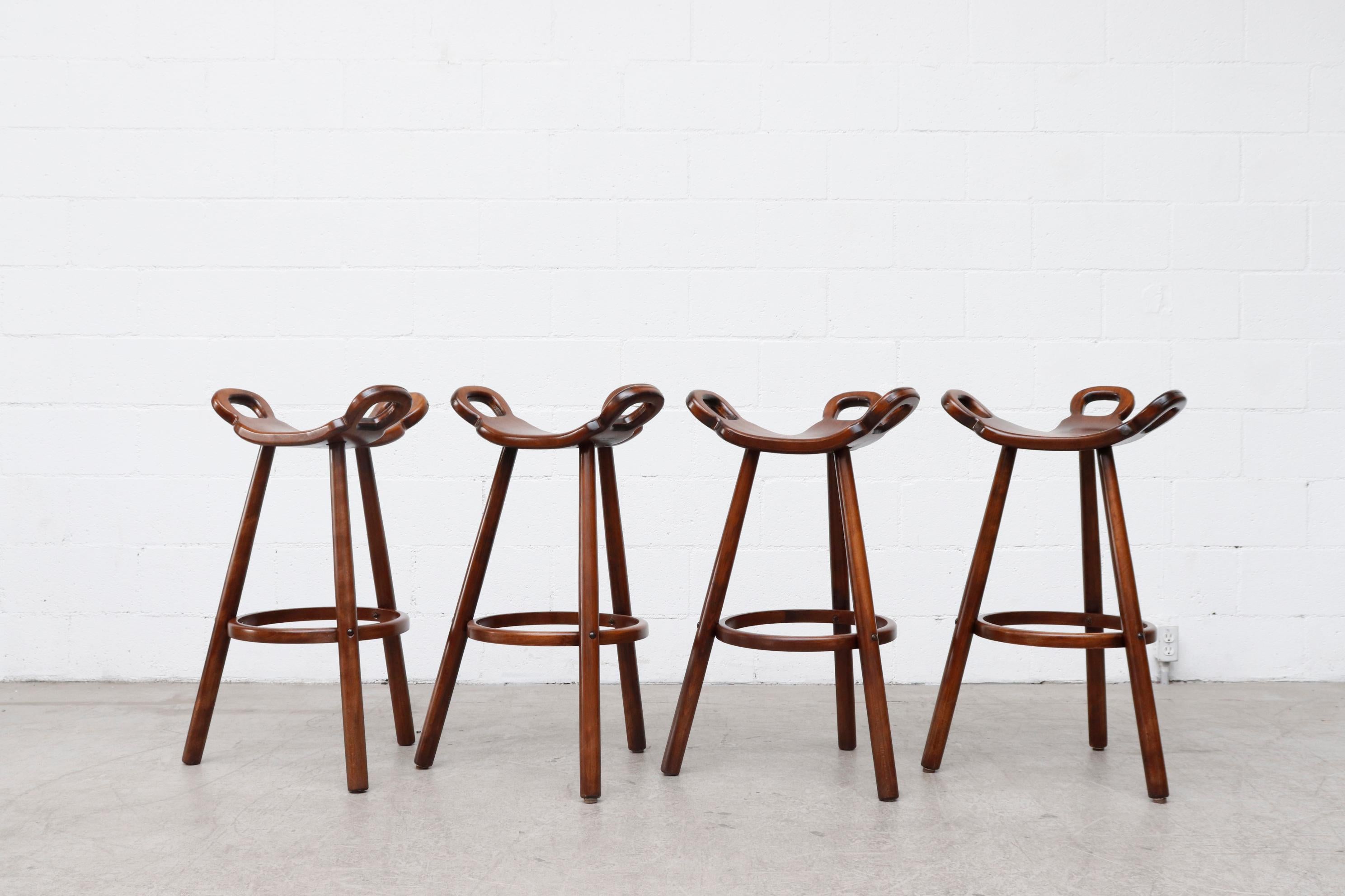 Set of 4 Sergio Rodrigues style Brutalist 'Marbella' bar stools by Confonorm. Organically carved seating and reverse tapered legs with wood footrests. Similar styles available with metal footrests. Listed separately. Set price.