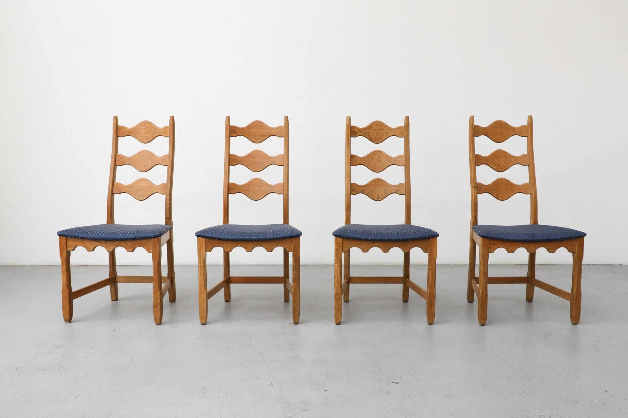 Set of 4 Brutalist decorative back, throne-like oak chairs designed by Henning Kjaernulf. These chairs have solid oak frames with an undulating decorative design theme and blue satin upholstered seats with a little diamond pattern. In original