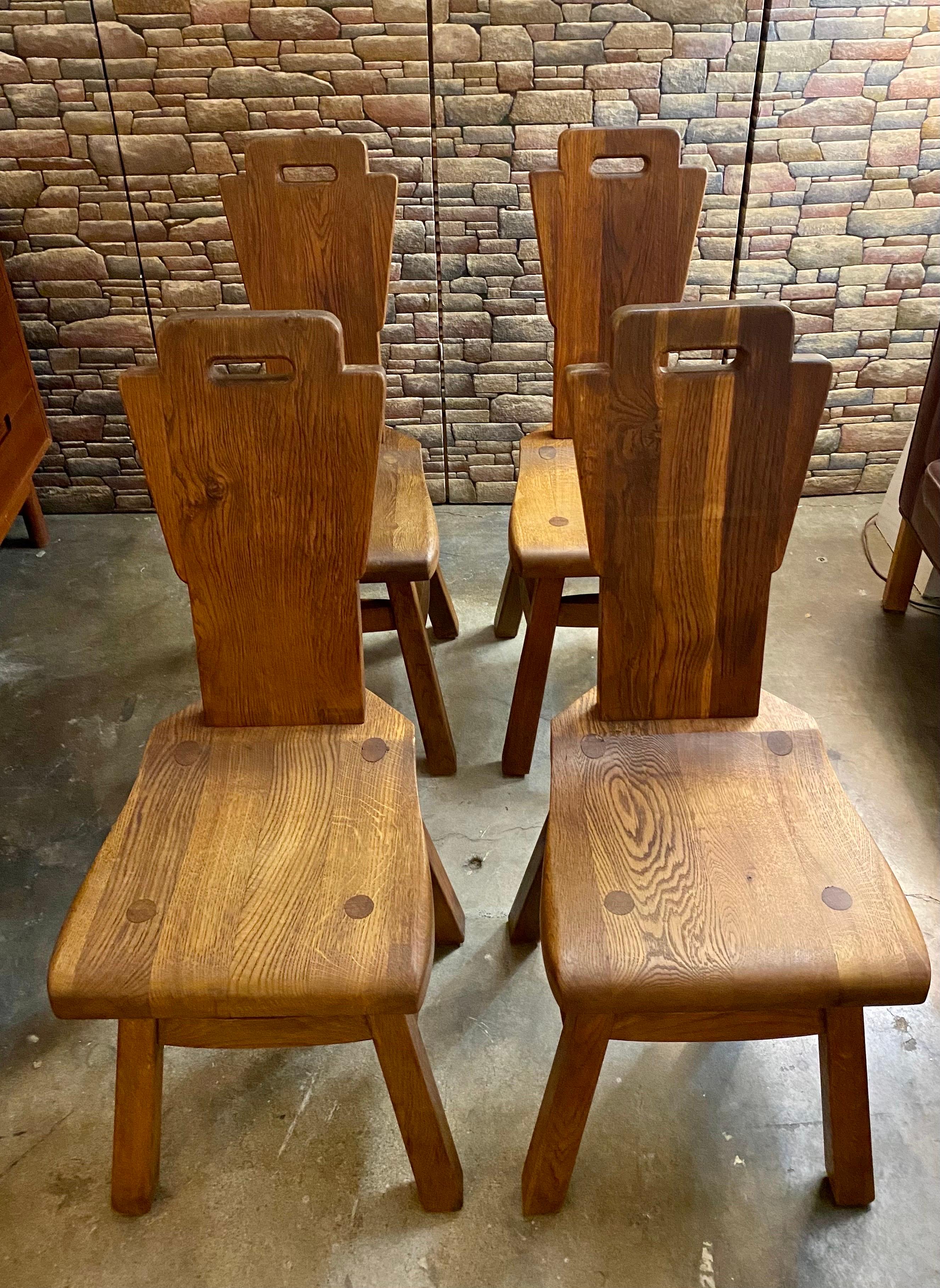 Set of 4 brutalist dutch dining chairs, circa 1970s made of solid oak, thick, heavy, sturdy, and in good overall condition; age-appropriate wear to the wood. The wood is a beautiful rich brown color. 
Dimensions: 15