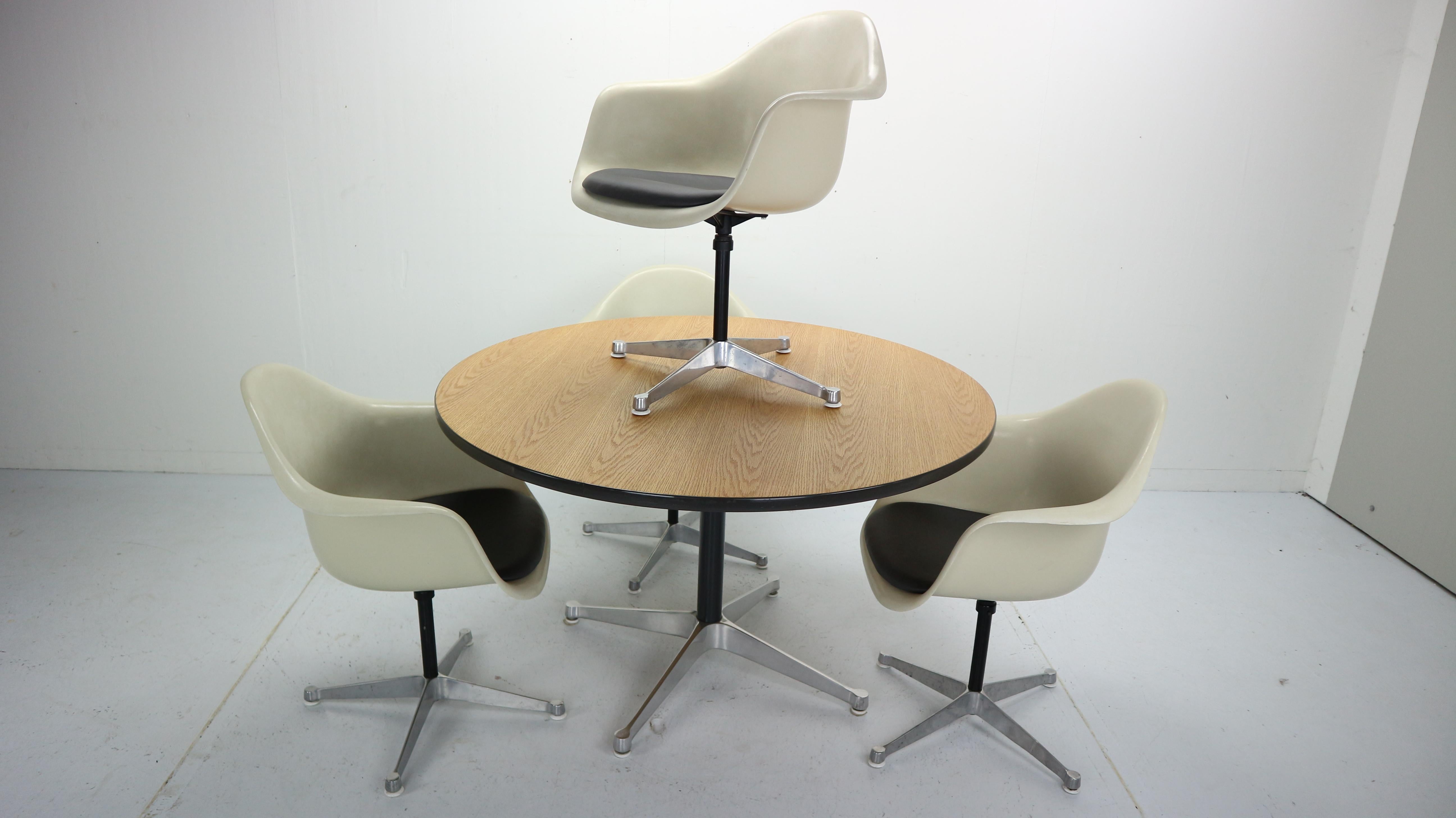 Gorgeous set of 4 bucket swivel chairs and round dining room table design by Charles and Ray Eames and manufactured by Herman Miller in 1950s-1960s period.
Charles and Ray Eames had ideas about making a better world, one in which things were