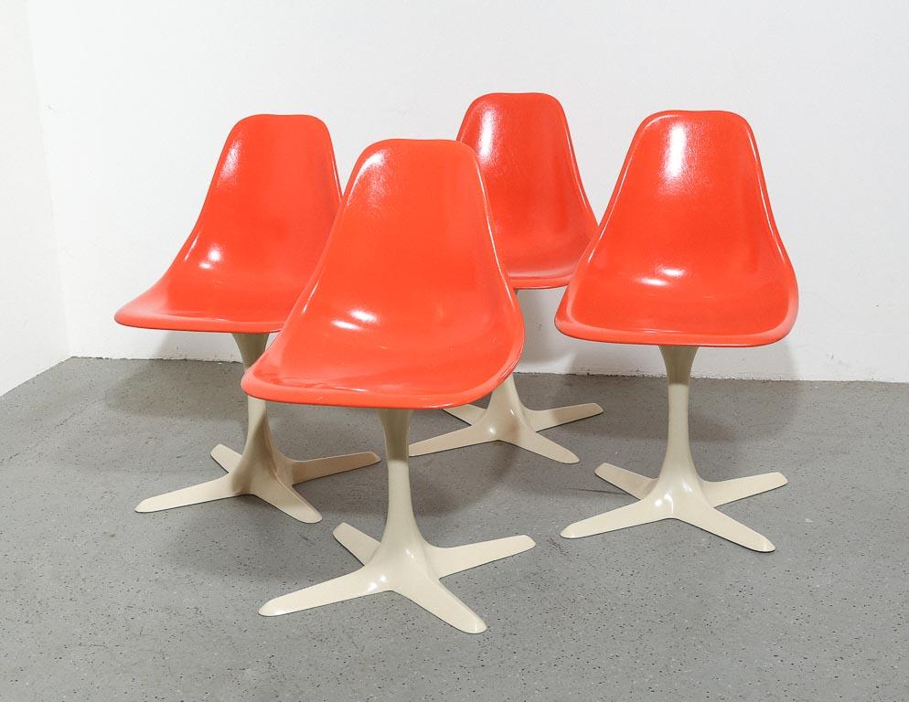 Set of 4 bright-orange fiberglass shell chairs by Burke on white painted cast aluminum 4-star bases. 17
