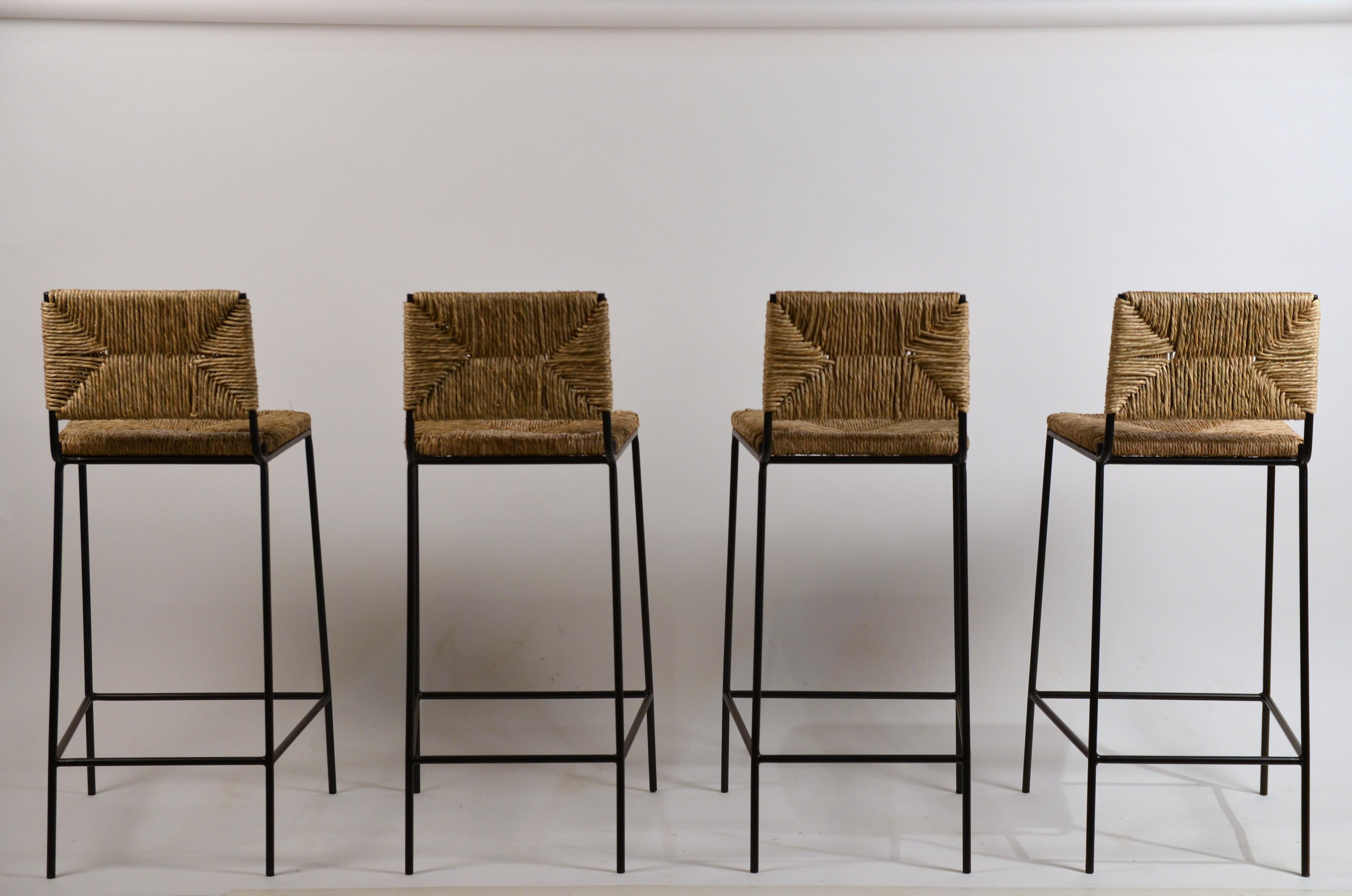 Set of 4 'Campagne' steel and rush counter stools by Design Frères.

Chic combination of slender but sturdy powder coated steel frames with handwoven rush seats and backs.

Support under the rush seat for durability.

Plastic caps on the feet