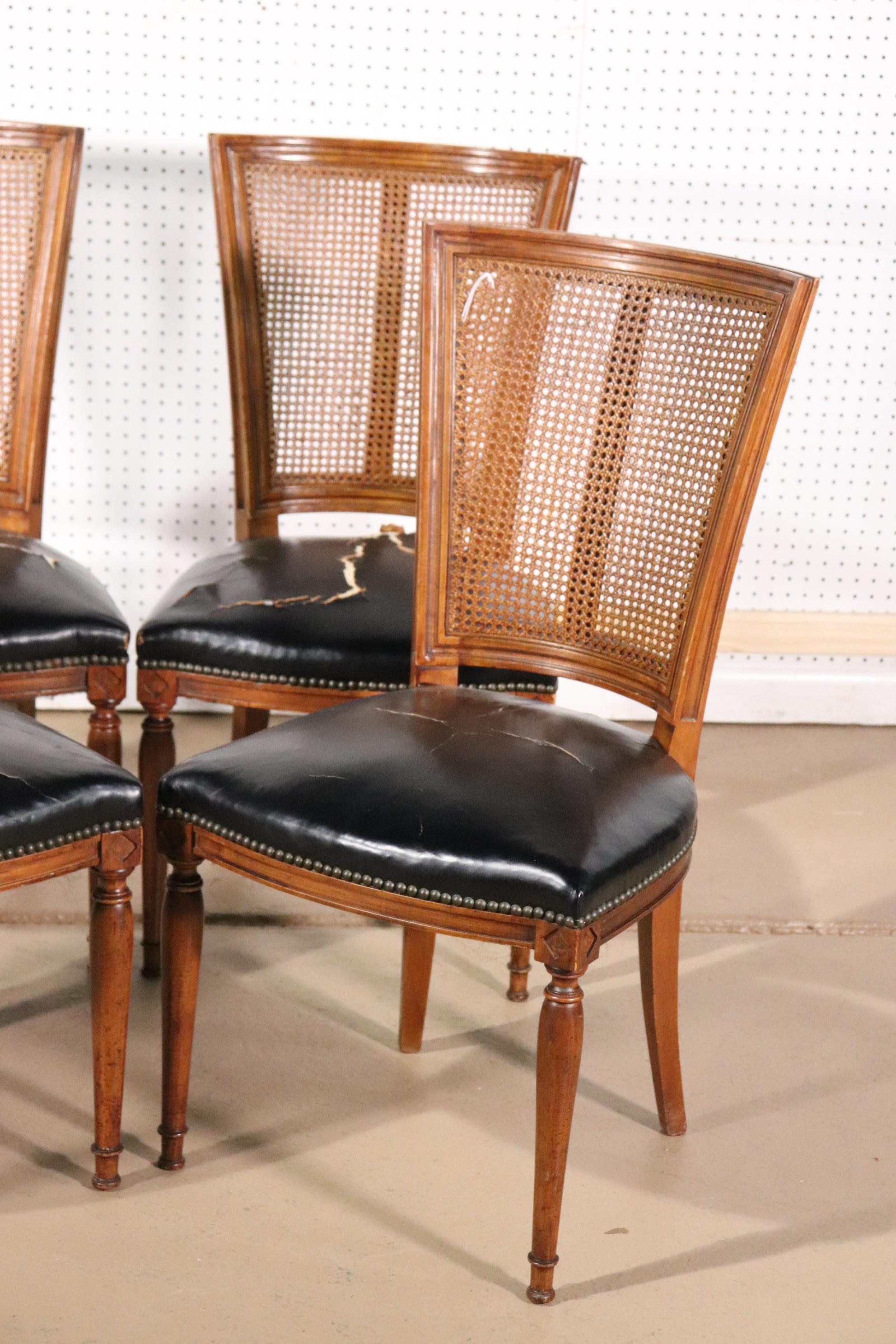 These dining chairs have beautiful cane backs and leather that has worn through in places. However this can be reupholstered or lived with. The chairs date to the 1940s and measure 37 tall x 22 deep x 20 wide x 18 inches for the seat height.