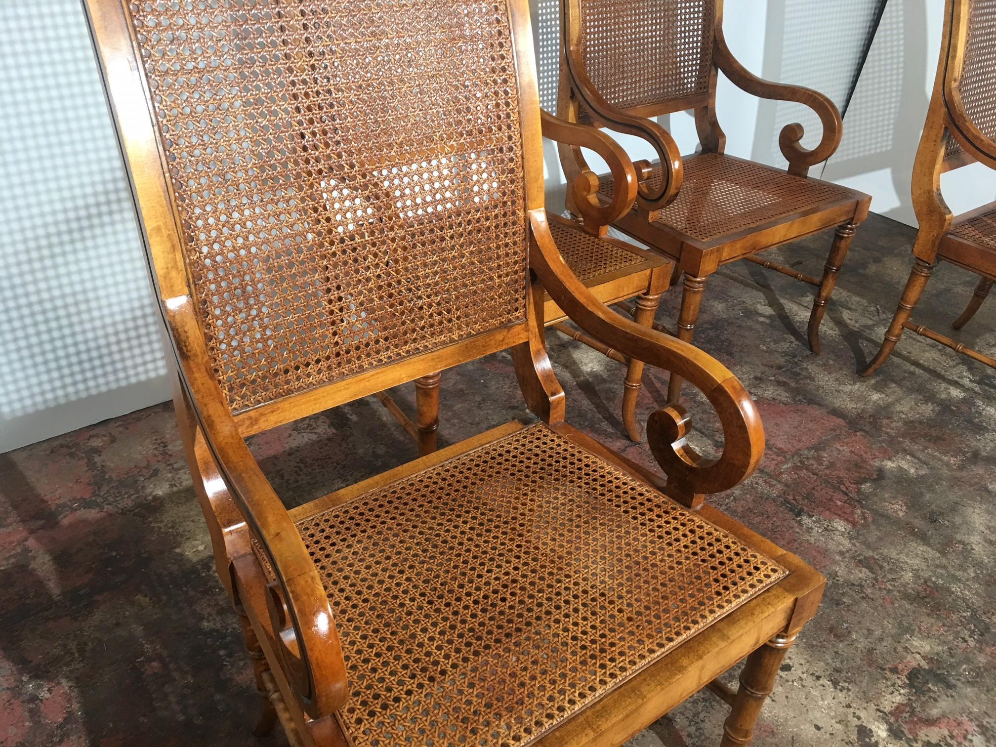 Set of four cane seat cane back dining room chairs. The arms are curved, and the legs are faux bamboo. Measure arm: 23.50
