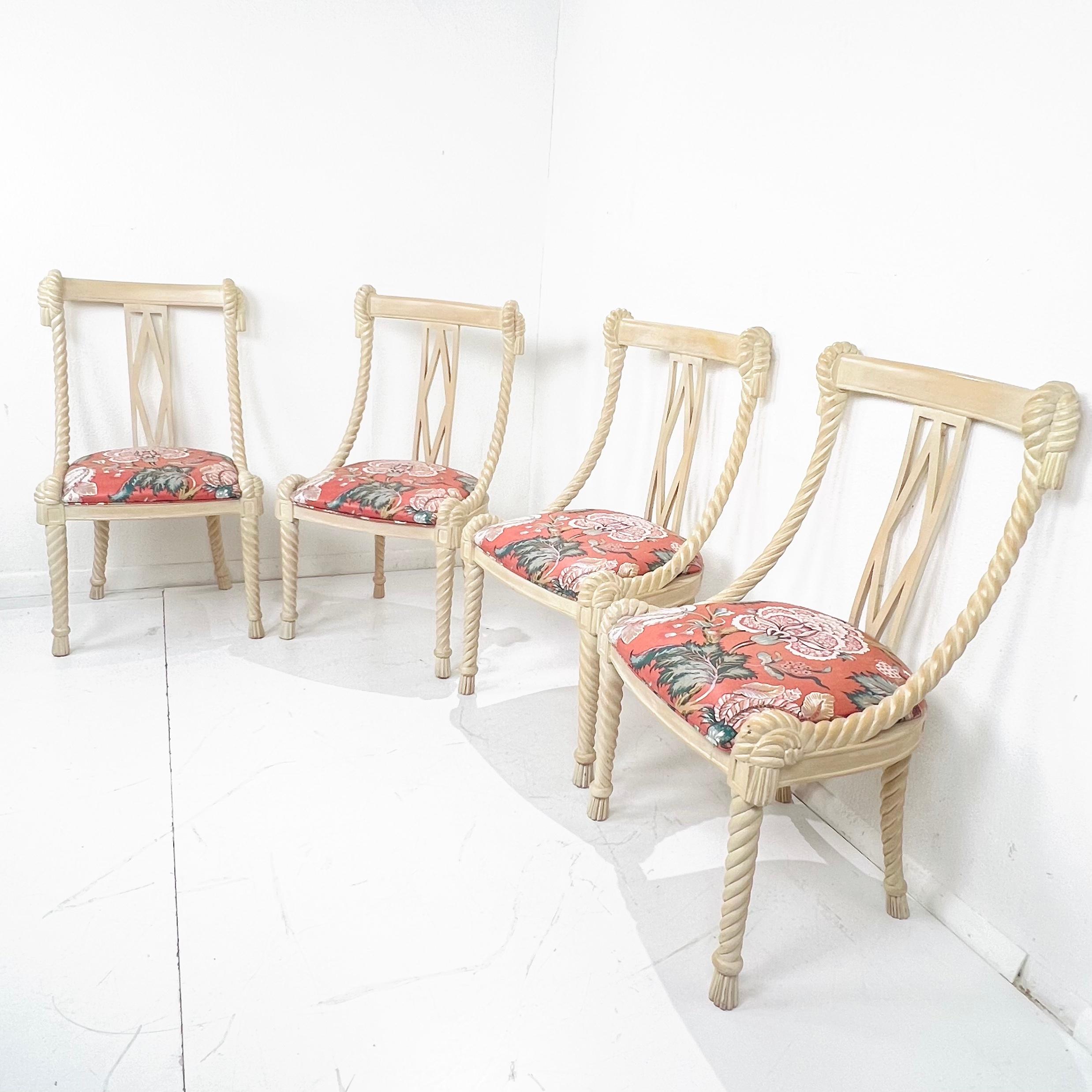 Set of four carved wood dining chairs by Andre Originals. Rope form legs and tassel feet with knotted seat corners, swaged sides rise up to knotted and tasselled seat back corners. Open back with elongated diamond shape centre. Floral upholstered