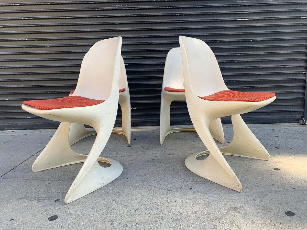 This set of four plastic chairs was designed by Alexander Begge in 1971 and manufactured by Casala, Germany.

 The model Casalino's have ivory colored frames and seats covered with the original red woolen fabric.

All of the chairs are