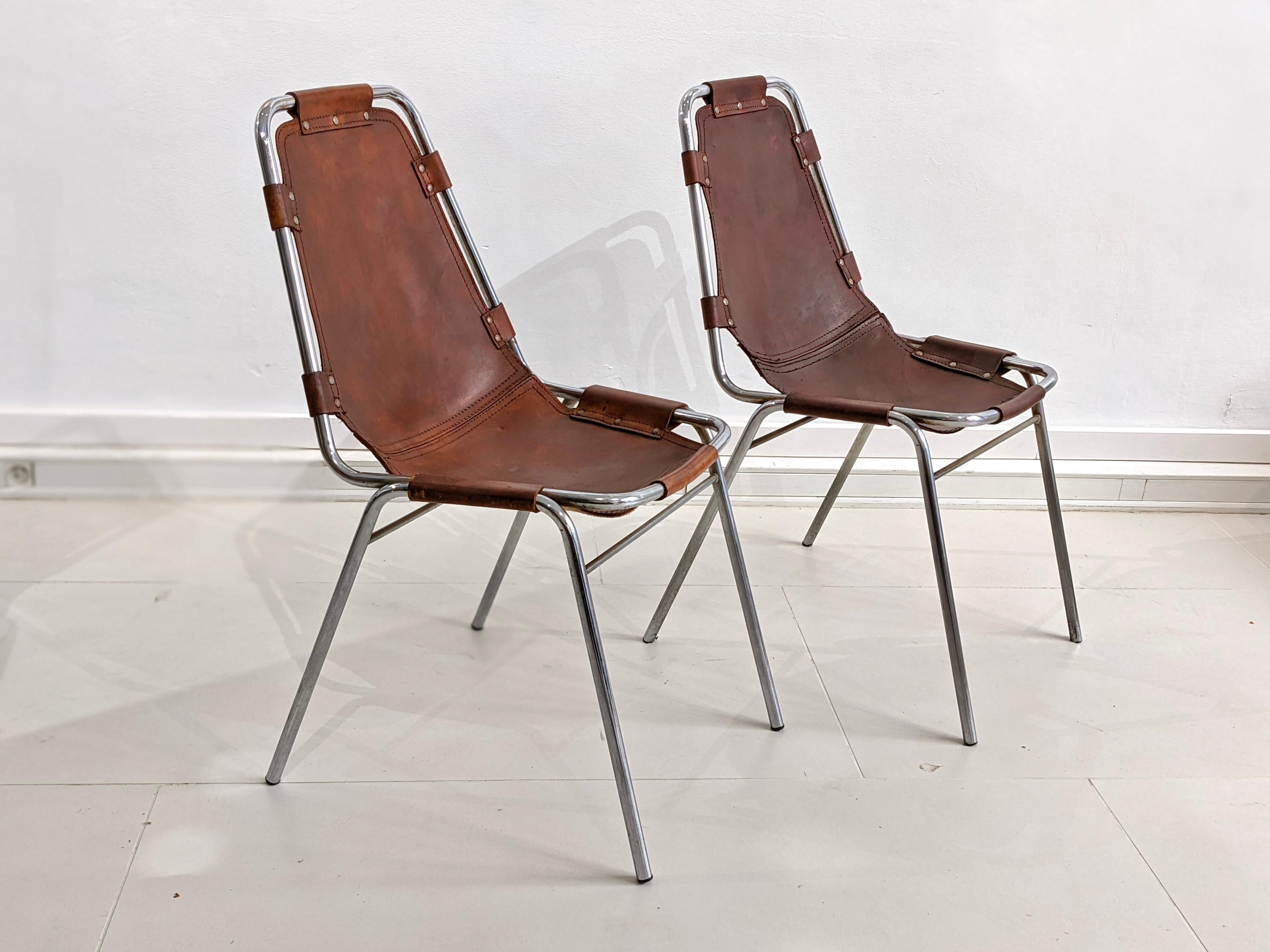 Set of 4 chairs by Charlotte Perriand for Les Arcs in cow skin leather. Good condition. Circa 1970

2 chairs have been reshaped at the level of the seat which explains the different colours of the leather (see photos). Traces of wear and