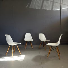 Set of 4 chairs design by Charles and Ray Eames for Vitra white shell and wood
