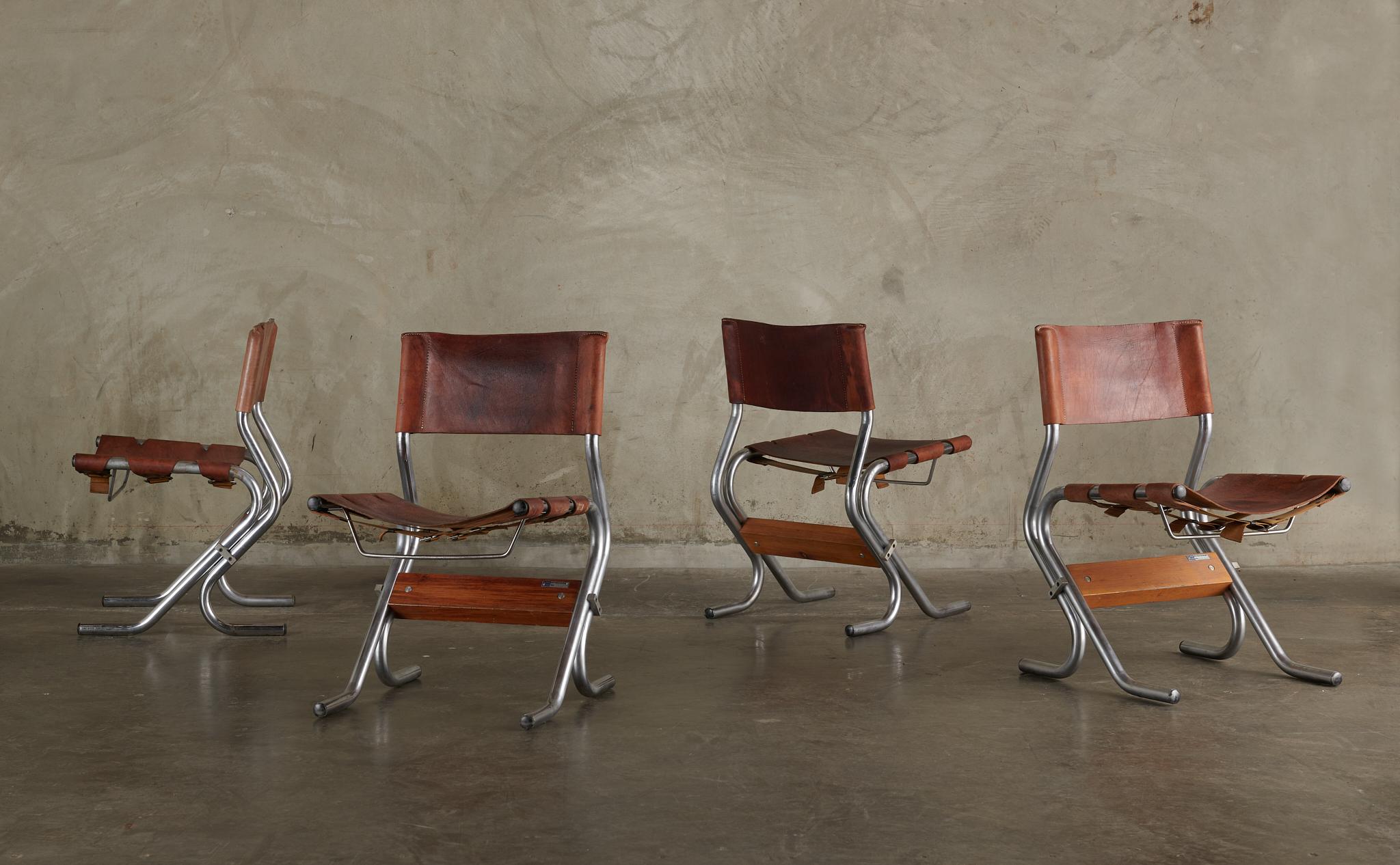 Extraordinaire ensemble de quatre chaises, avec cuir cognac d'origine et base polie au chrome. Conçus pour le ROOMS, ces sièges en bandoulière sont confortables, polyvalents et conviendraient à n'importe quelle pièce.