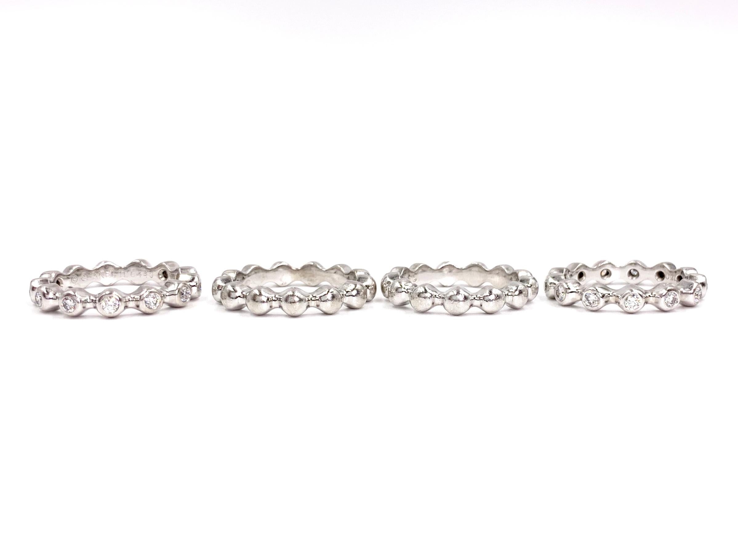 Set of four signed CHANEL solid 18 karat white gold stackable rings. Two of the rings feature 13 burnished diamonds at .48 carats total weight each (.96 carats total weight between the two). Diamond quality is F color, VVS1 clarity. Rings are