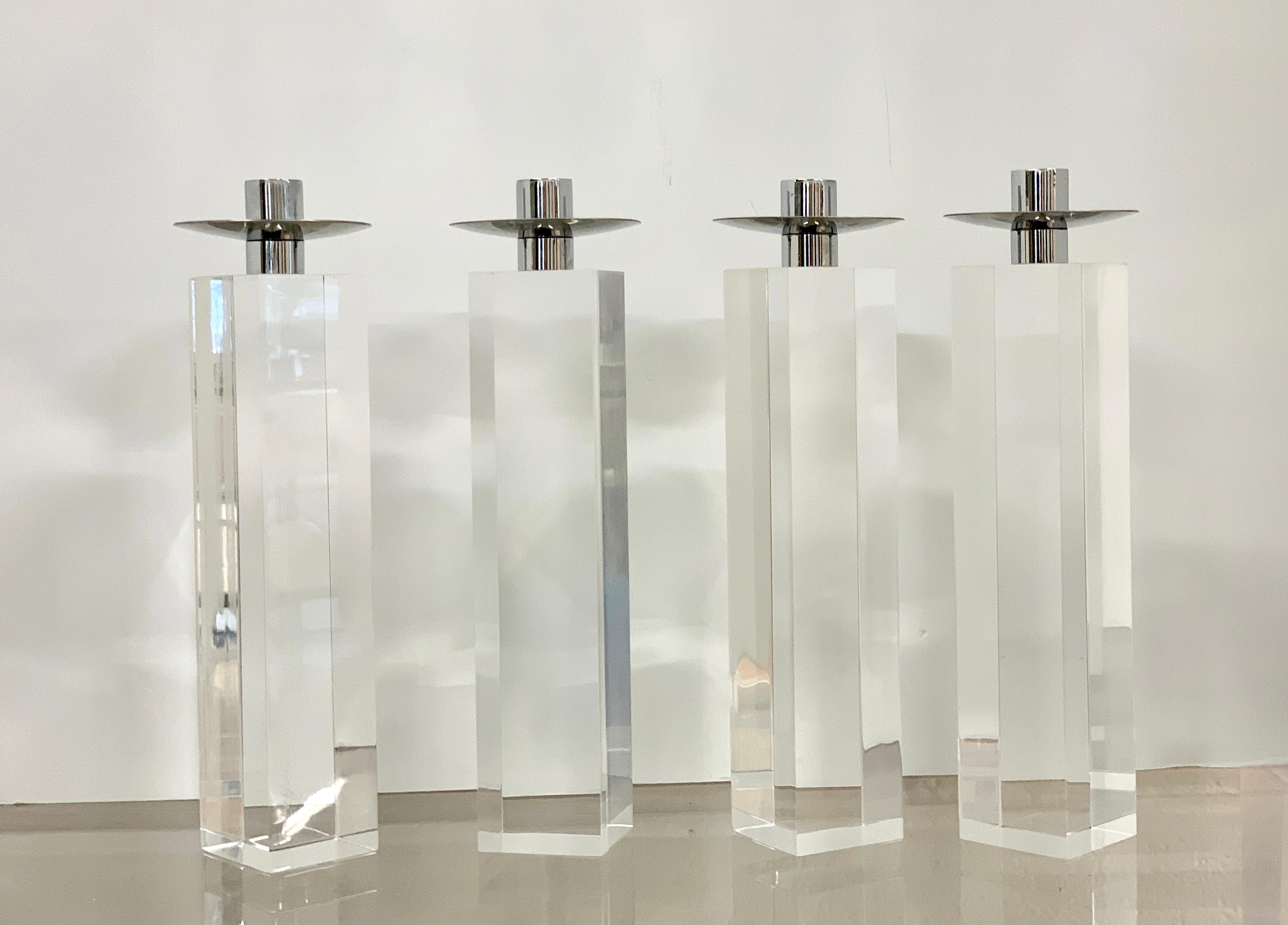 A set of 4 Charles Hollis Jones nickel and Lucite candleholders or candlesticks. One is signed on the signed. They are in good condition with some minor marks to the nickel and Lucite, pictured. They are approximately 10 1/4 inches tall and the
