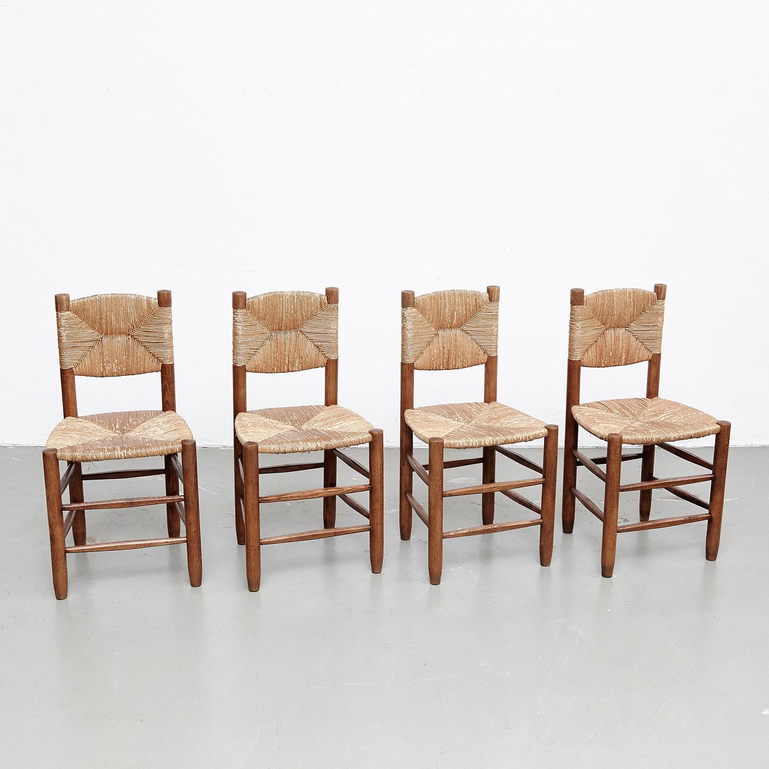 Set of four chairs designed by Charlotte Perriand, circa 1950.
Manufactured in France.

 Made in wood base and legs with rush seat.

In original condition, with minor wear consistent with age and use, preserving a beautiful patina.