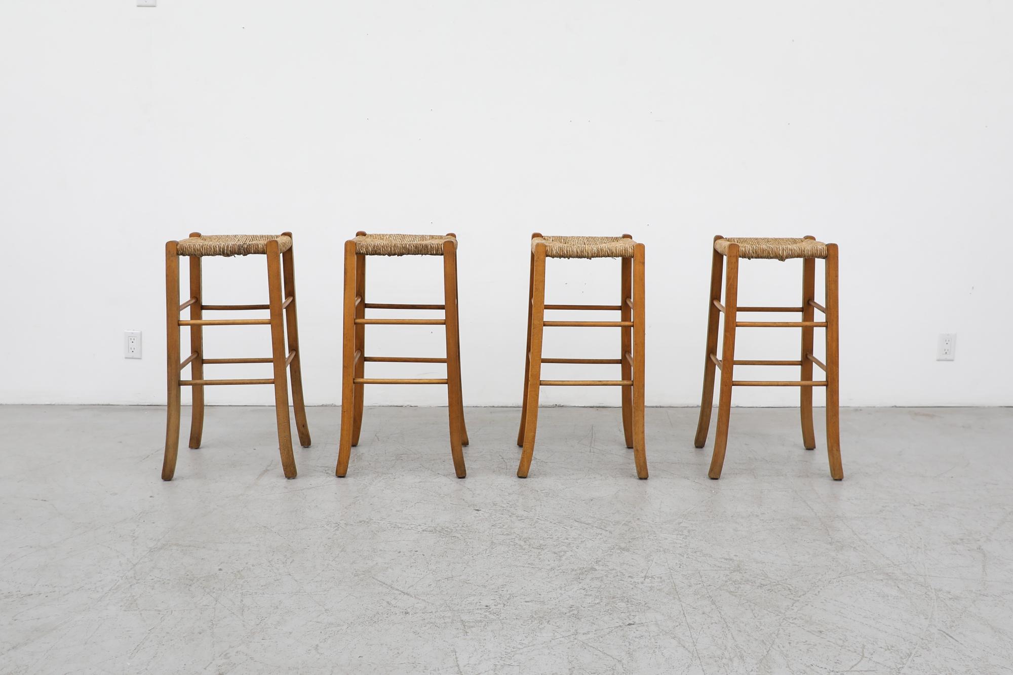 Set of 4 Charlotte Perriand style oak bar stools with beautifully woven rush seats and slightly angled legs. Seat height is 30