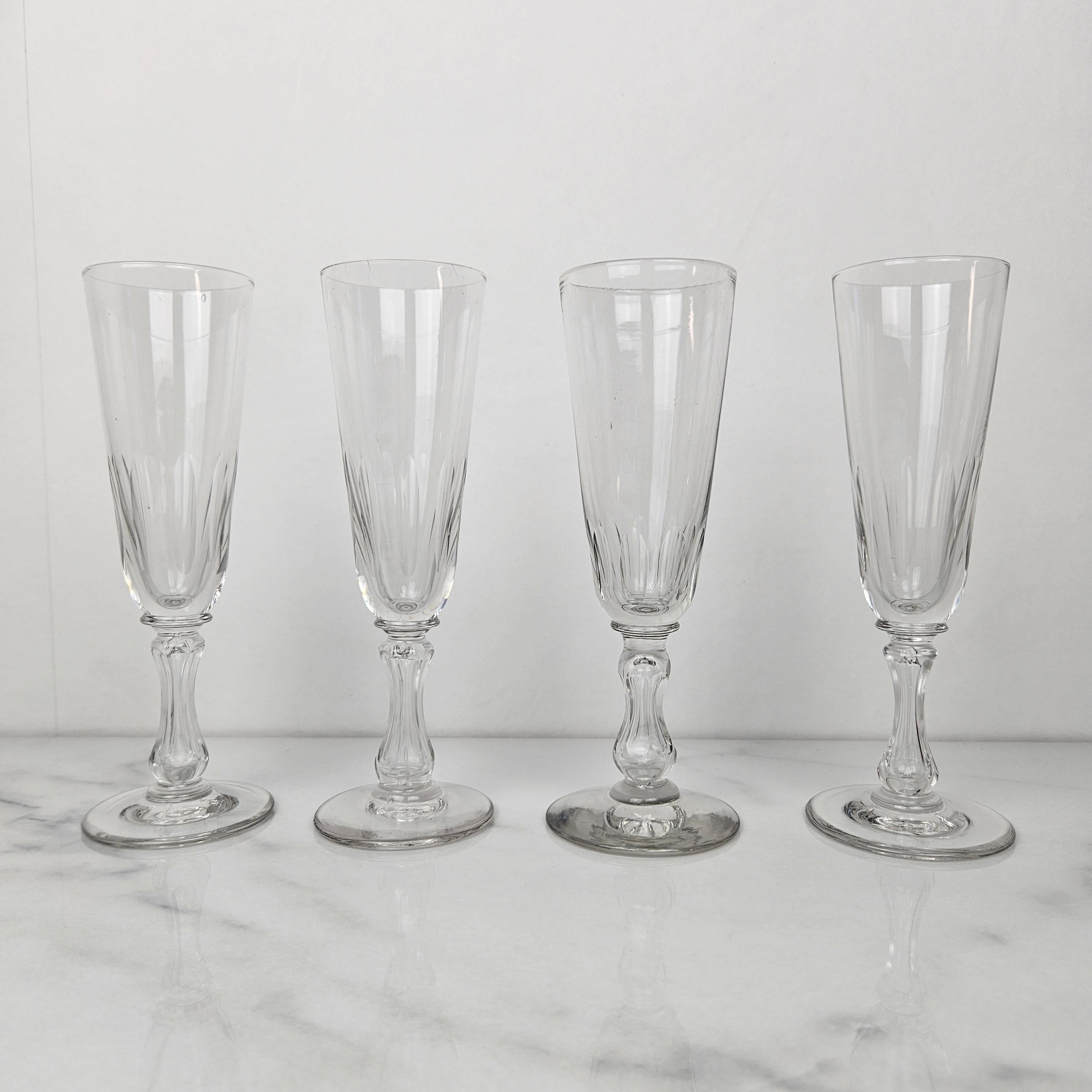Un ensemble raffiné de 4 coupes à champagne françaises anciennes, fabriquées en verre clair vers 1890. 
Les flûtes sont dotées d'un bol inférieur magnifiquement taillé et d'une tige avec des détails décoratifs taillés, offrant à la fois un intérêt