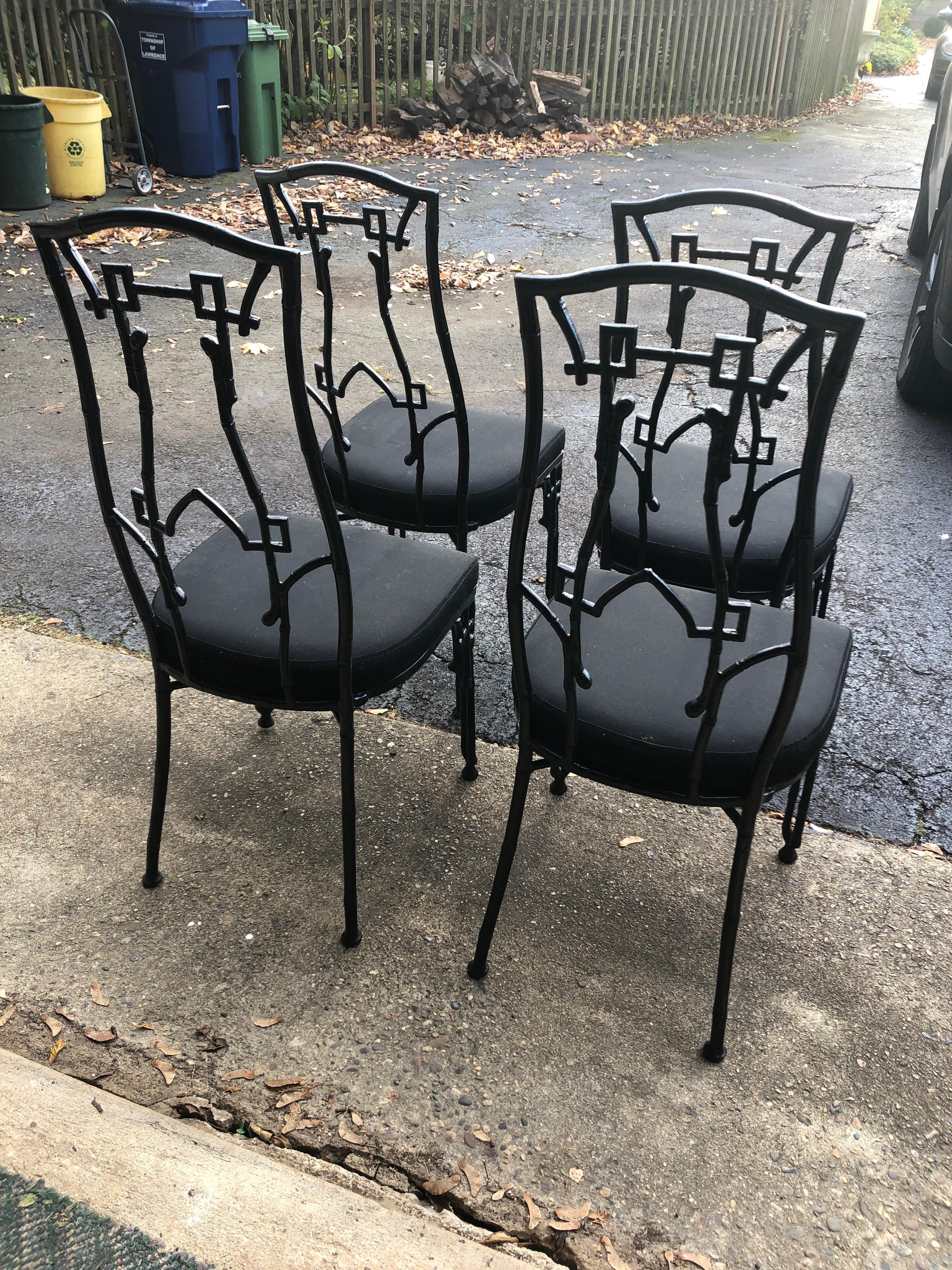 Set of 4 chic black painted iron patio chairs having a stylish chinoiserie silhouette. Upholstered seats are Sunbrella, but a bit tired. Priced accordingly.