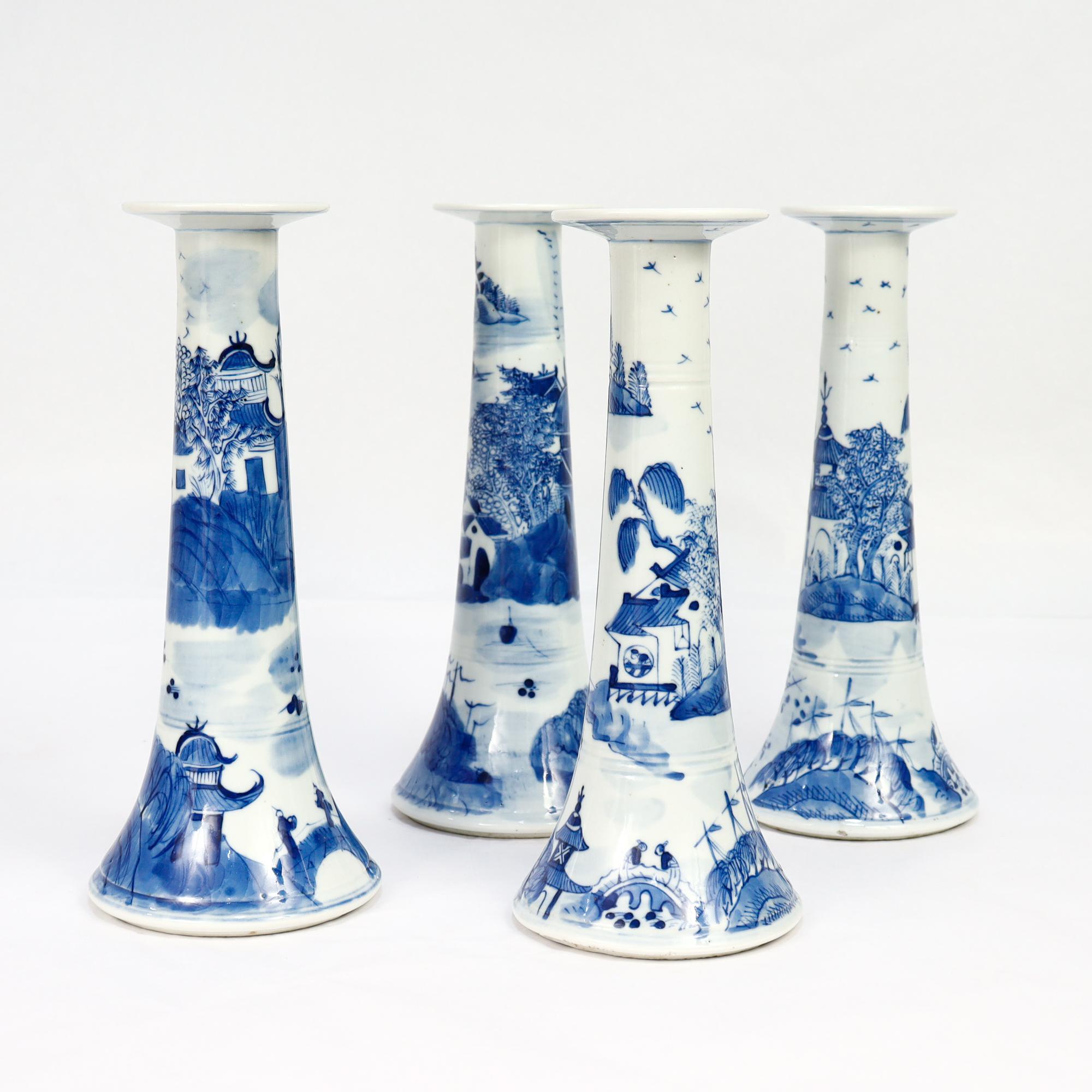 A fine set of 4 antique Chinese Export porcelain candlesticks.

In the Canton pattern.

Each in an inverted trumpet form and decorated in underglaze blue with a mountainous Chinese village with houses, mountains, foliage, and a river and boat.
