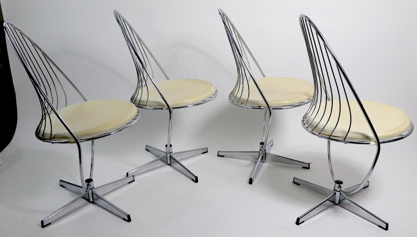 Stylish Postmodern chrome dining, or kitchen, chairs. The chairs swivel and tilt on a center post, which is mounted on a chrome star base. Design in the style of Vernon Panton, manufacture attributed to Chromecraft. All chairs are in very Fine,