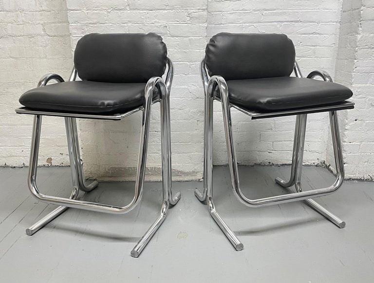 Set of four vintage stools by Jerry Johnson. Black vinyl seats and backs with tubular chrome frames.
 