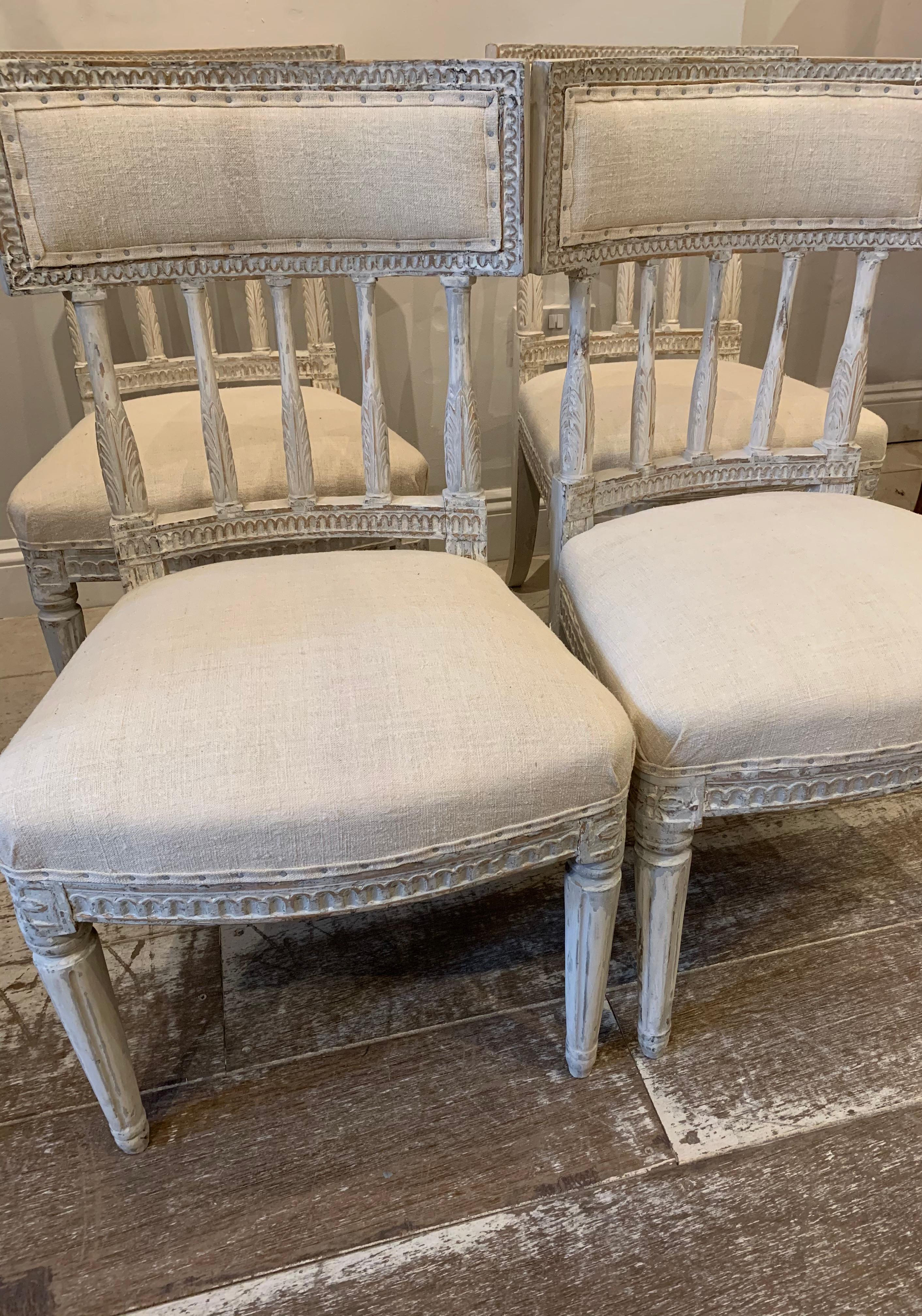 A lovely set of four Swedish Gustavian painted dining chairs circa 1800s.
The chairs are sturdy and have deep comfortable seats upholstered in a neutral vintage French linen.
The chairs have carved detailing to the frame and to their spindle backs