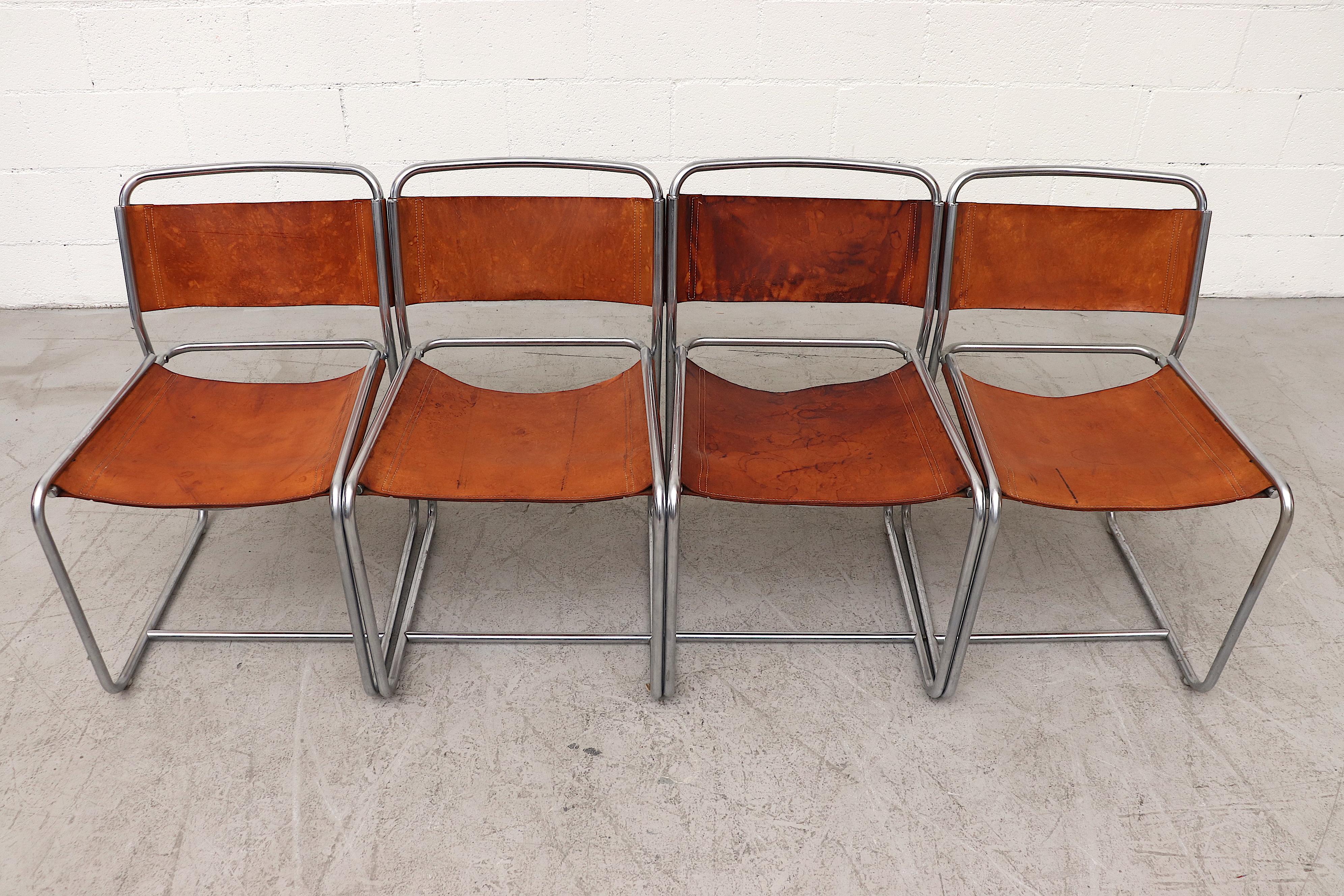 Rare set of Claire Bataille and Paul Ibens Model SE18 leather dining chairs for 't Spectrum, Netherlands, 1971. Nickel plated tubular steel frames with original saddle leather seating visible patina, with heavy staining and wear. Stunning minimal