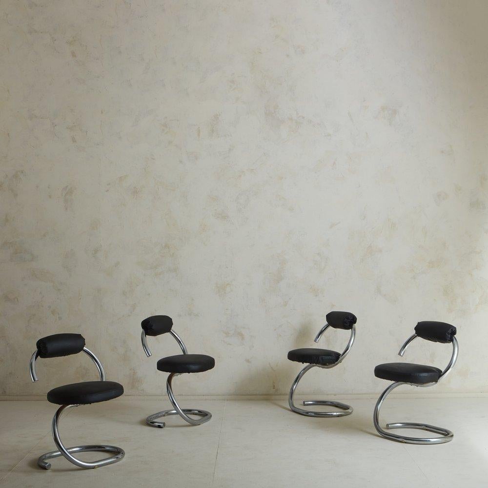 A set of 4 Italian Cobra chairs designed by Giotto Stoppino in the 1970s. These cantilevered chairs feature curved, tubular chrome frames, which extend seamlessly from the base to the backrest. They have upholstered backrests and circular seats,