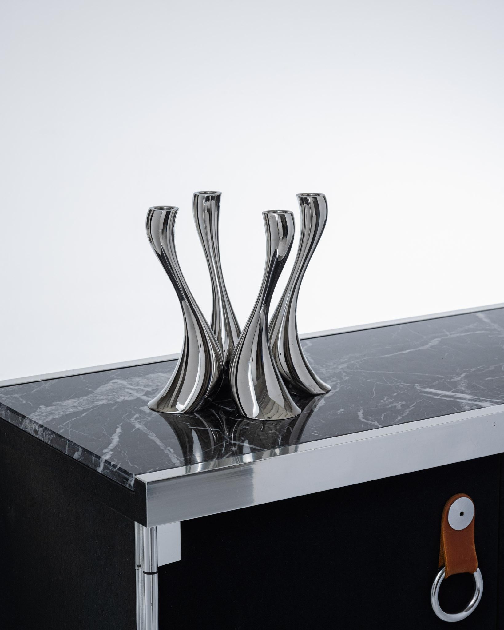 Set of 4 candleholders from the Cobra collection, produced by Georg Jensen in the 2000s. Made of polished metal, featuring the organic and flowing design typical of contemporary Scandinavian style. Very good condition.

DV4627-DV4628-DV4629-DV4630