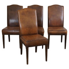 Ensemble de 4 chaises de salle à manger en cuir de mouton couleur cognac avec une belle patine.