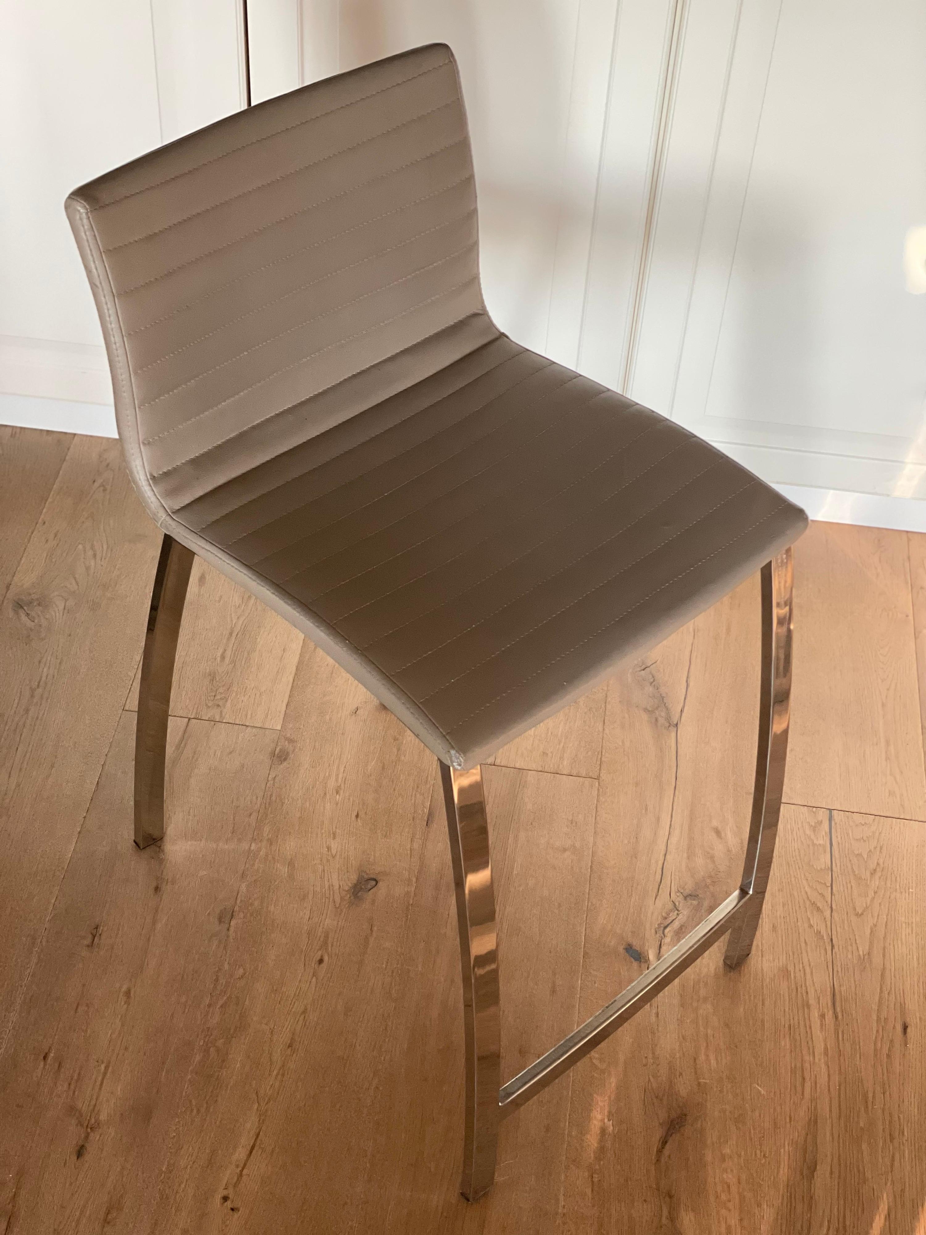 Tabouret de bar ou de comptoir de style italien moderne. Fabriqué en acier inoxydable chromé de haute qualité pour plus de solidité, il a été conçu dans un souci de style et de confort. Le cuir chic présente de belles surpiqûres et une belle patine.