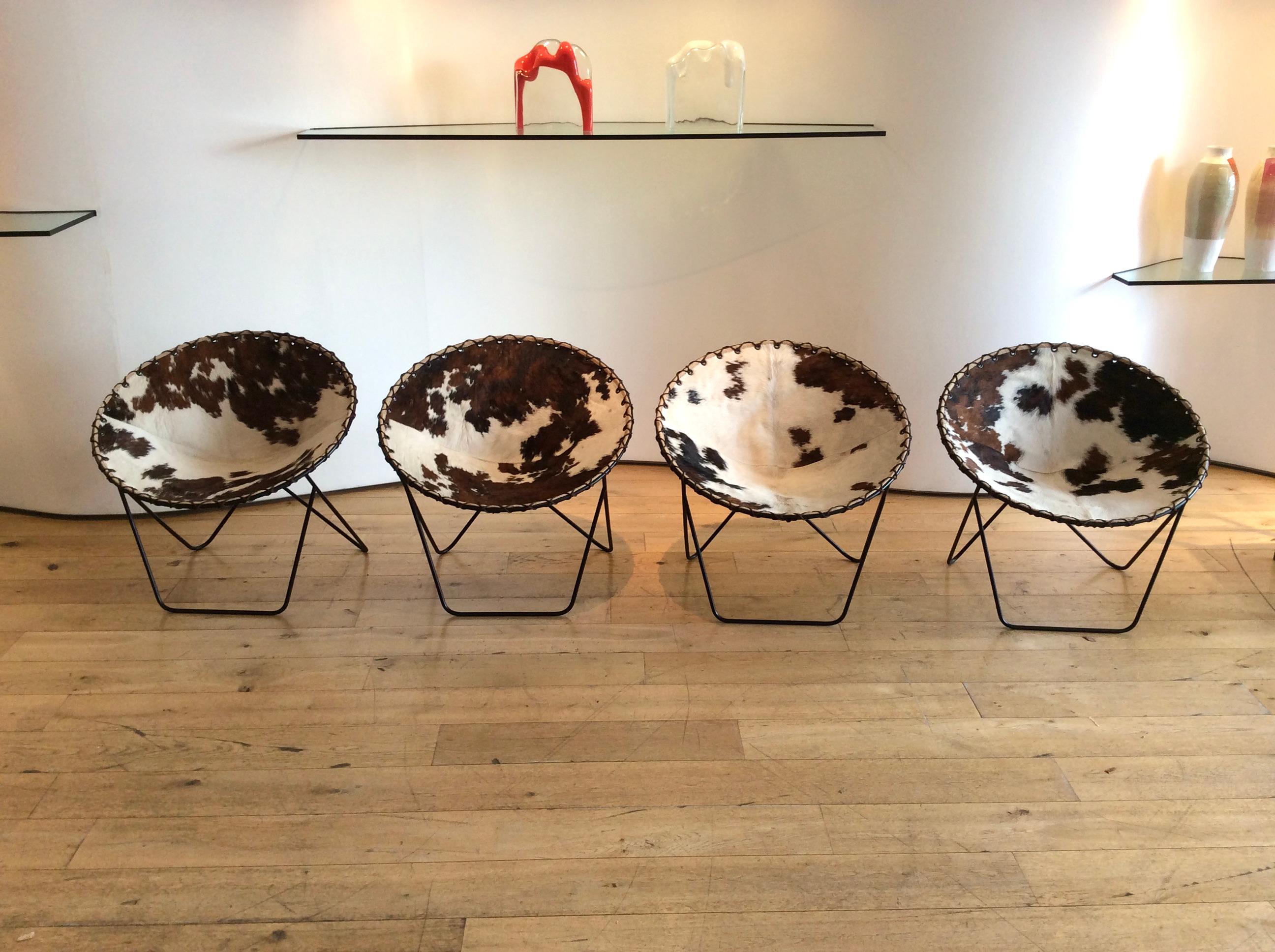 Charming set of 4 circular chairs in cowhide, perfect for relaxed seating.
Metal legs with cowhide seats edged with grommets whip-stitched to metal frame.