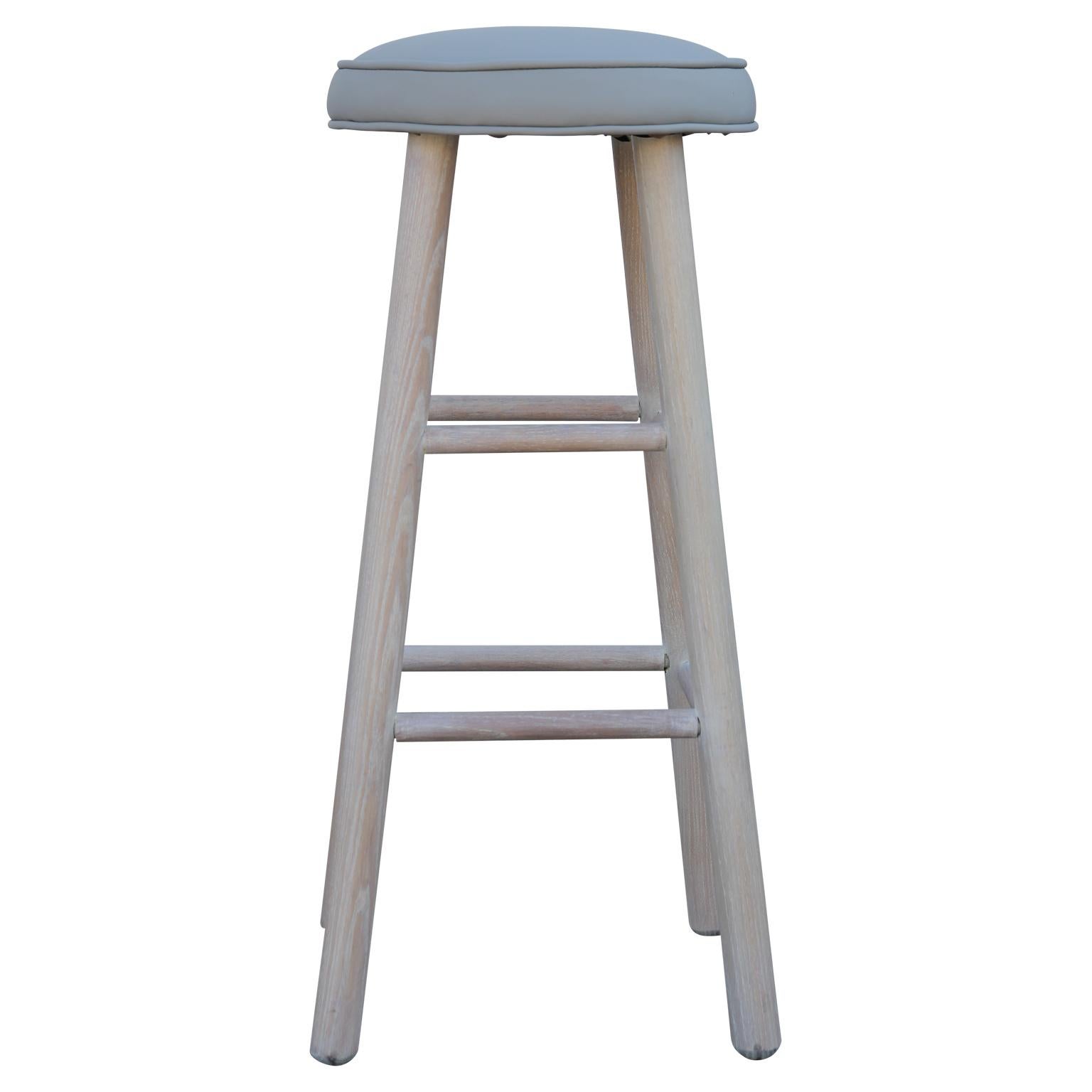 Set of 4 newly refinished barstools with light gray leather and a white washed oak base. Each chair has 2 sets of rungs for stability and support.
