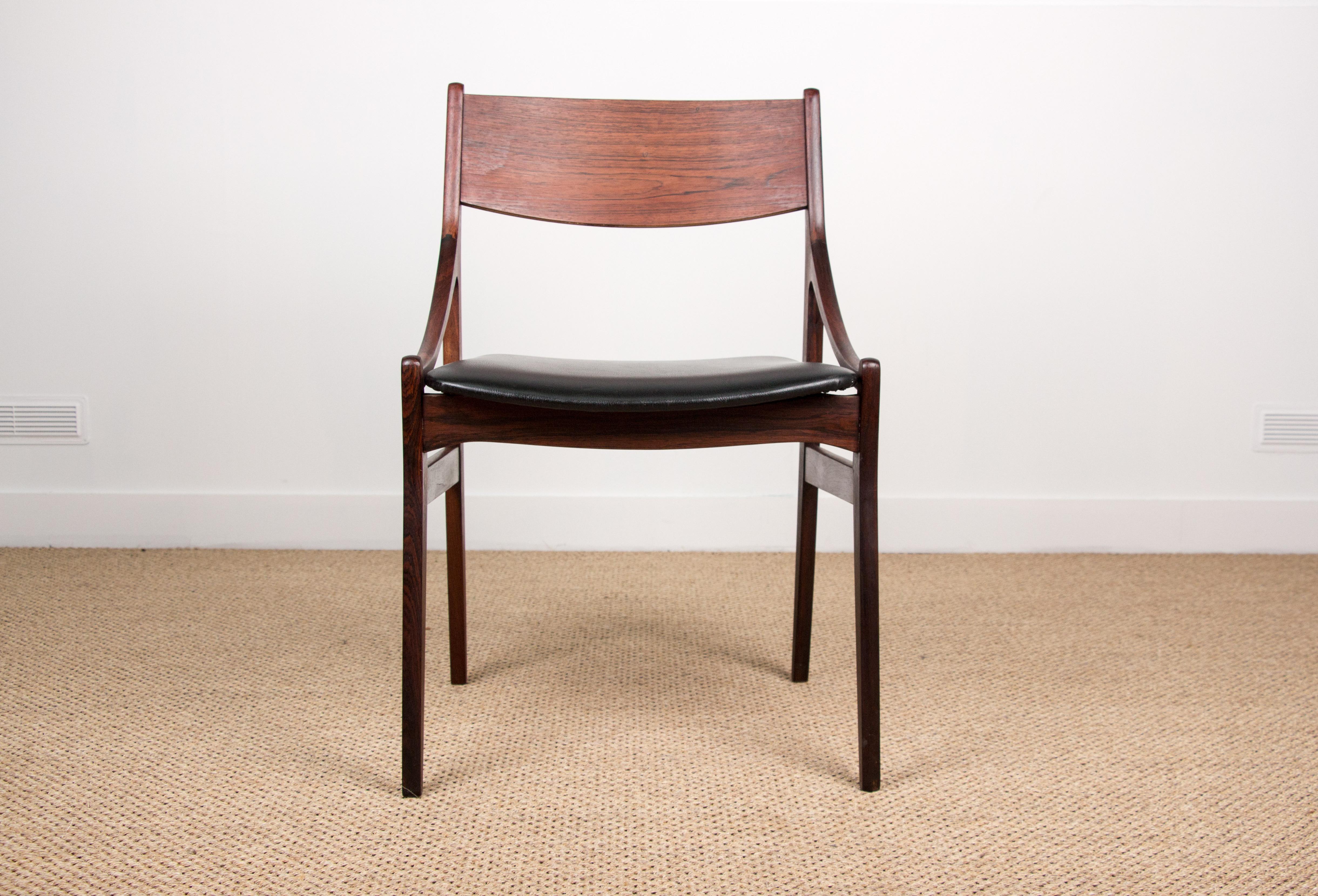 Ensemble de quatre chaises de salle à manger scandinaves, avec assise en similicuir noir et beau grain de bois. Les accoudoirs incurvés et les dossiers pleins confèrent à ces chaises une grande élégance, presque brutaliste, et un grand confort. Un