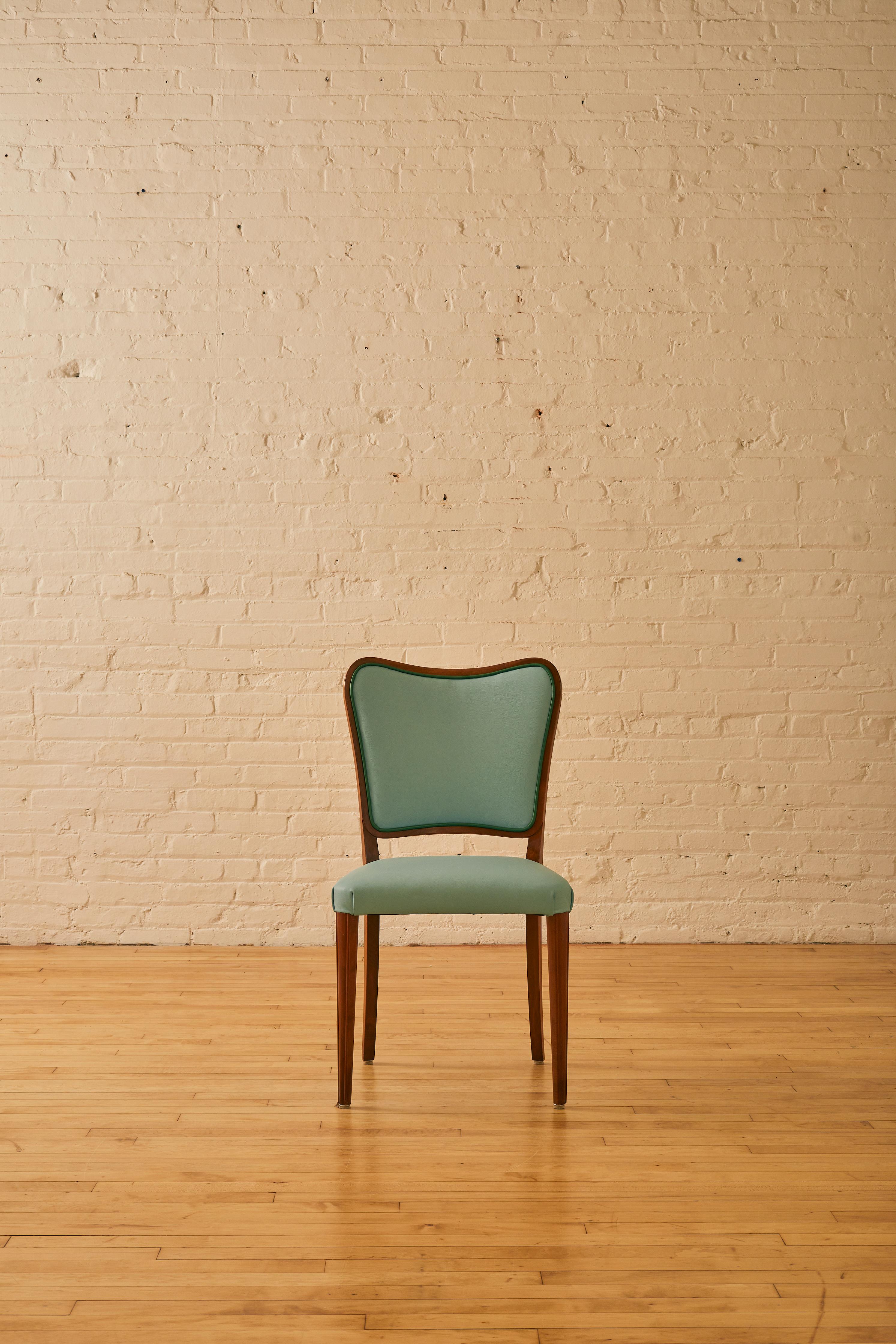 Set of 4 Danish Dining Chairs with teak wood. Newly reupholstered in light blue Italian leather with green leather piping.