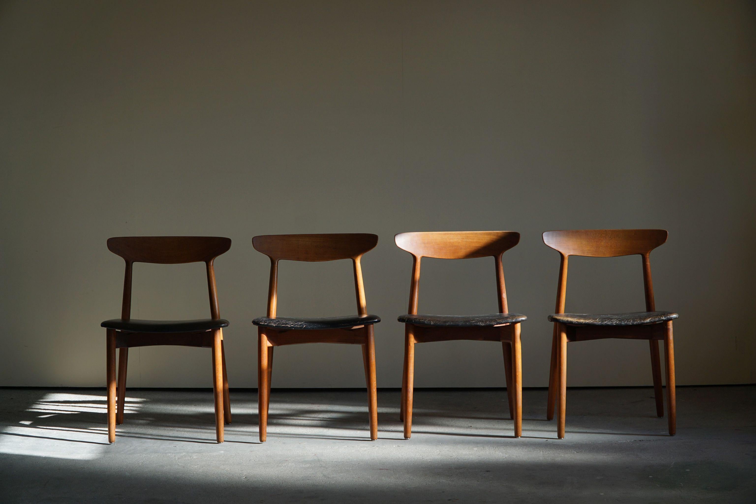 Set of 4 Danish mid century dining chairs by Harry Østergaard in teak and patinated black leather. Model 59, produced by Randers Møbelfabrik. 

A nice curved back featured in these chairs.

General good vintage condition.
 