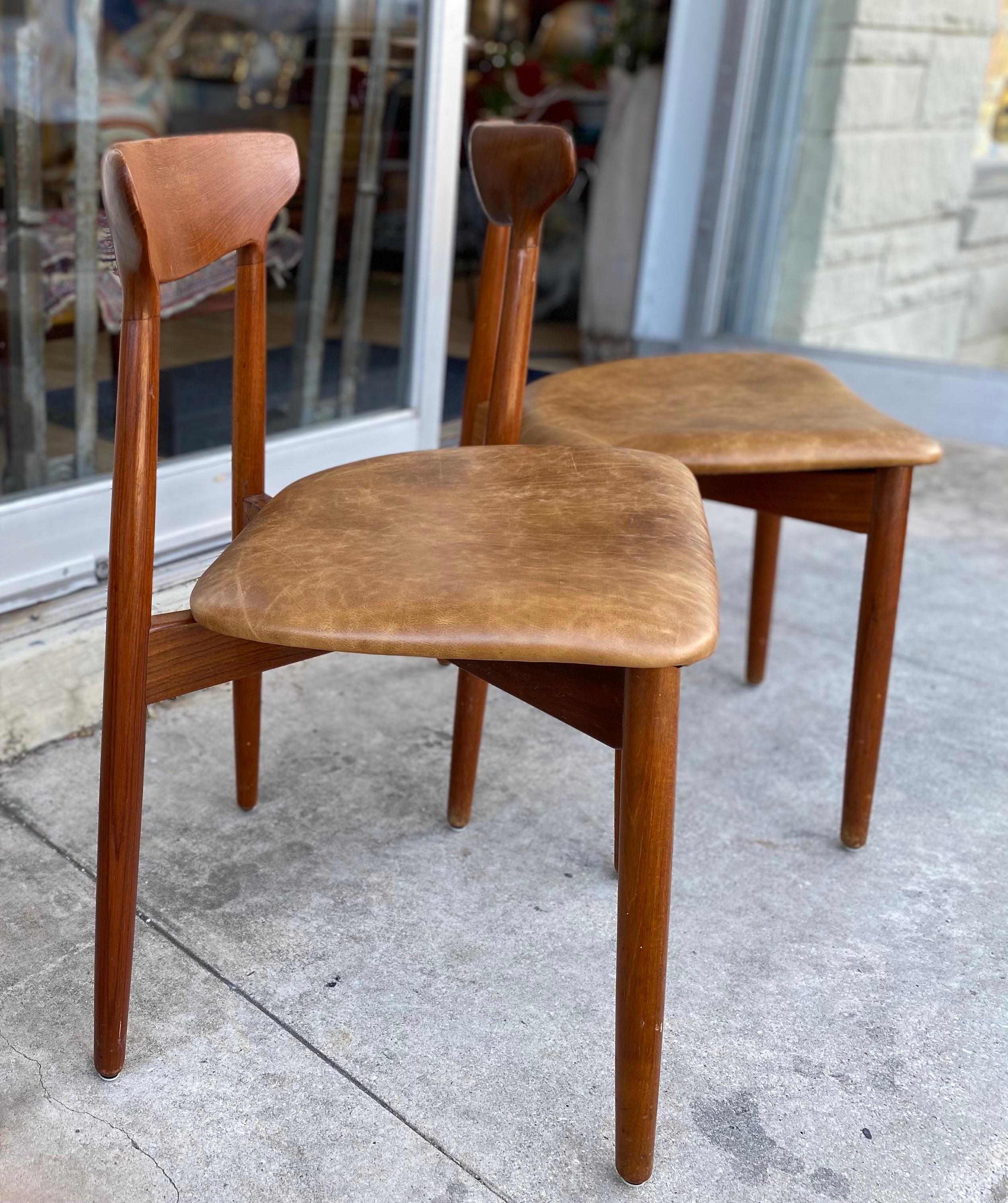Beautiful set of four Mid-Century Modern Danish dining chairs designed by Harry Østergaard made of teak and tan leather seating, circa 1970s. This set of four danish modern dining chairs are in great overall vintage condition.