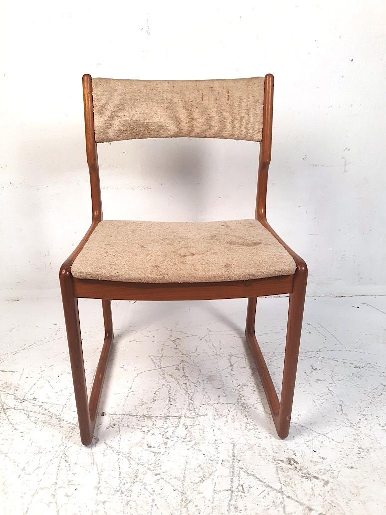 Hard to find set of four vintage Danish teak dining chairs designed by Benny Linden. Featuring his classic sculptural solid frames with exquisite joinery and highlighted by the unusual sled leg design adding both sturdiness and classic aesthetics.