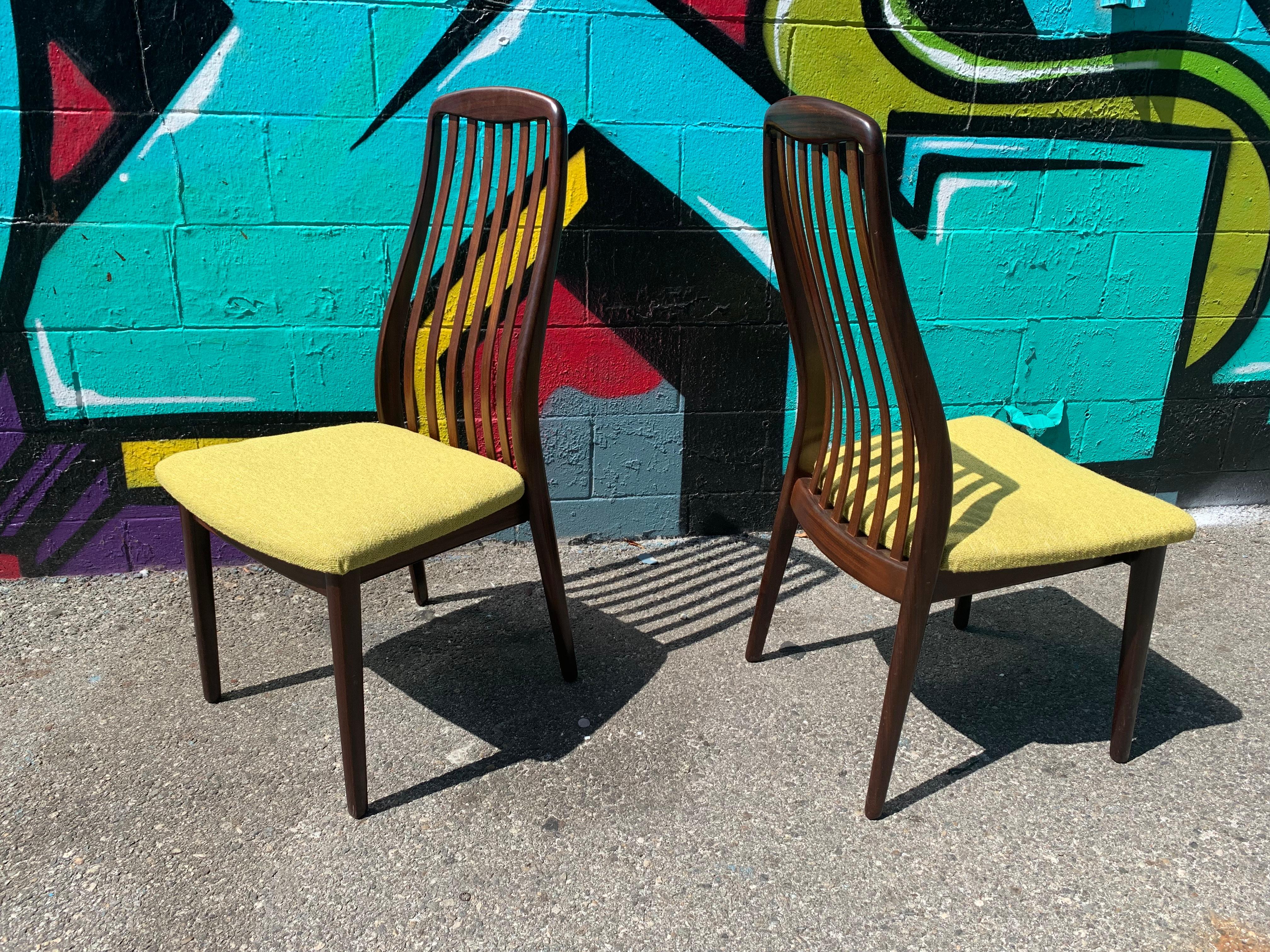 This complete set of dining chairs was manufactured by Dyrlund of Denmark in the 1960s. There are clean lines and nice shape/movement to an otherwise fairly traditional slat-back design.