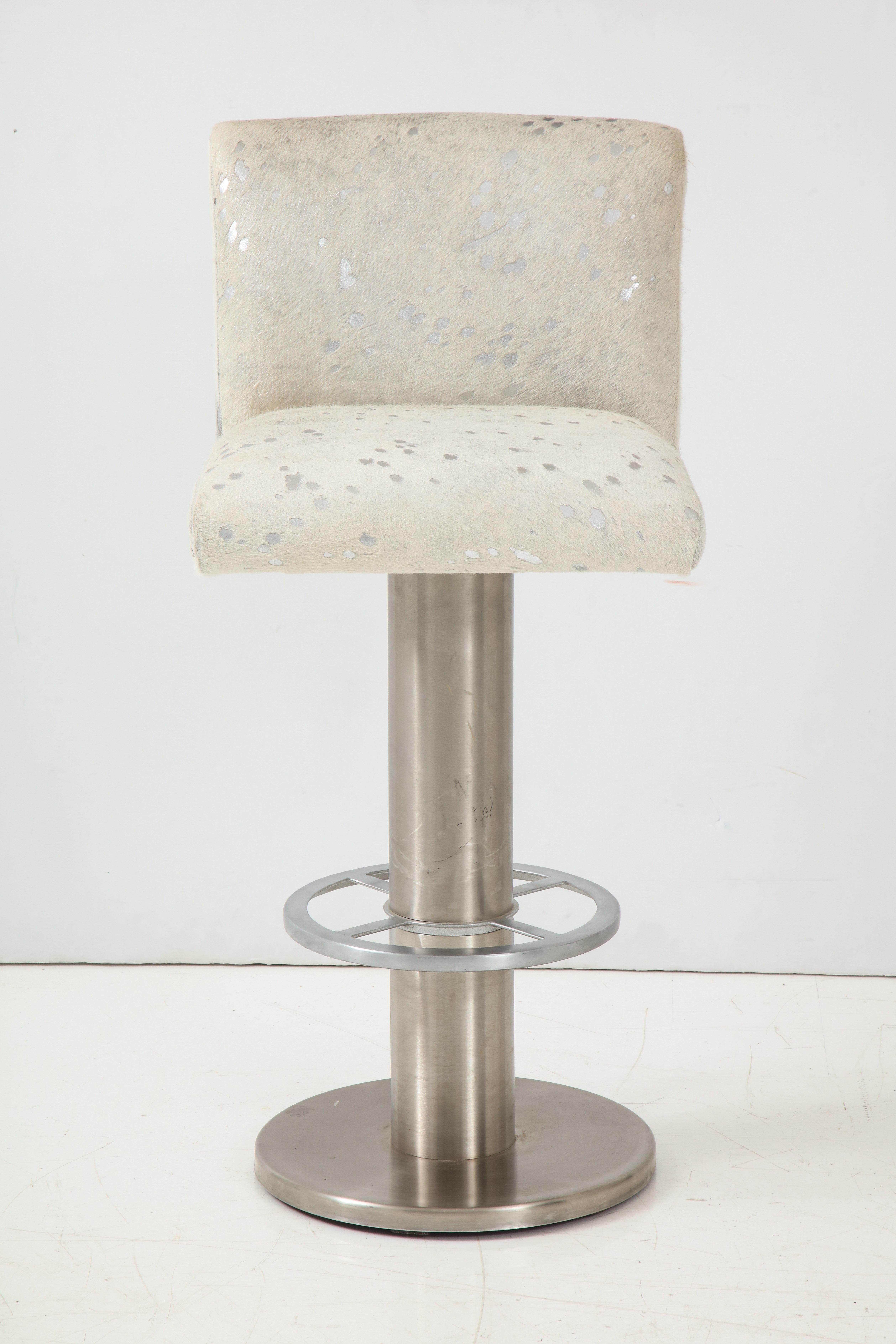 Set of 4 brushed steel swivel bar stools upholstered in white hair on hide with silver metallic abstracted shading. New upholstery and padding.