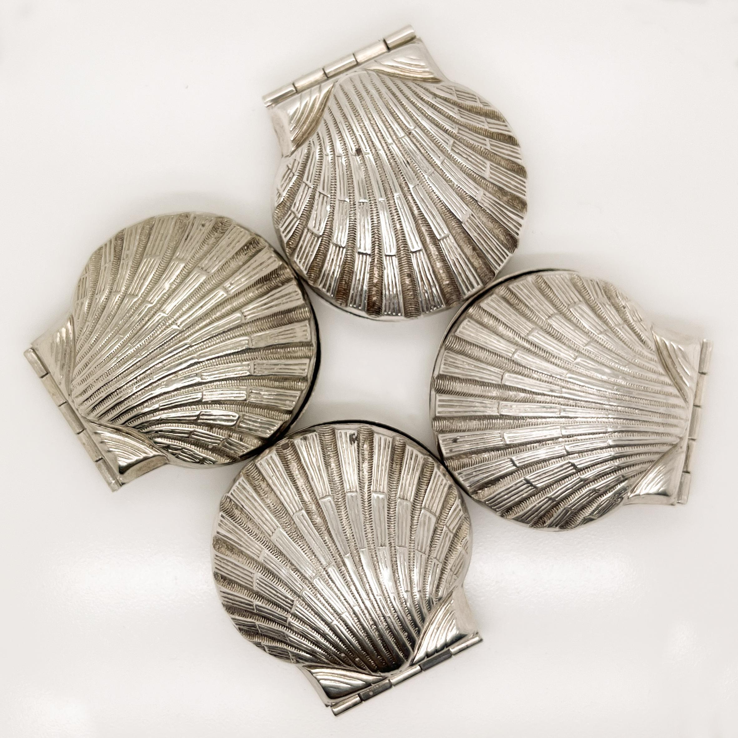 A wonderful group of 4 figural sterling silver boxes.

In the shape of hinged scallop sea shells.

These little boxes are perfect for the vanity or dresser for use as ring box and can also serve as dinner place card holder.

Simply wonderful objet