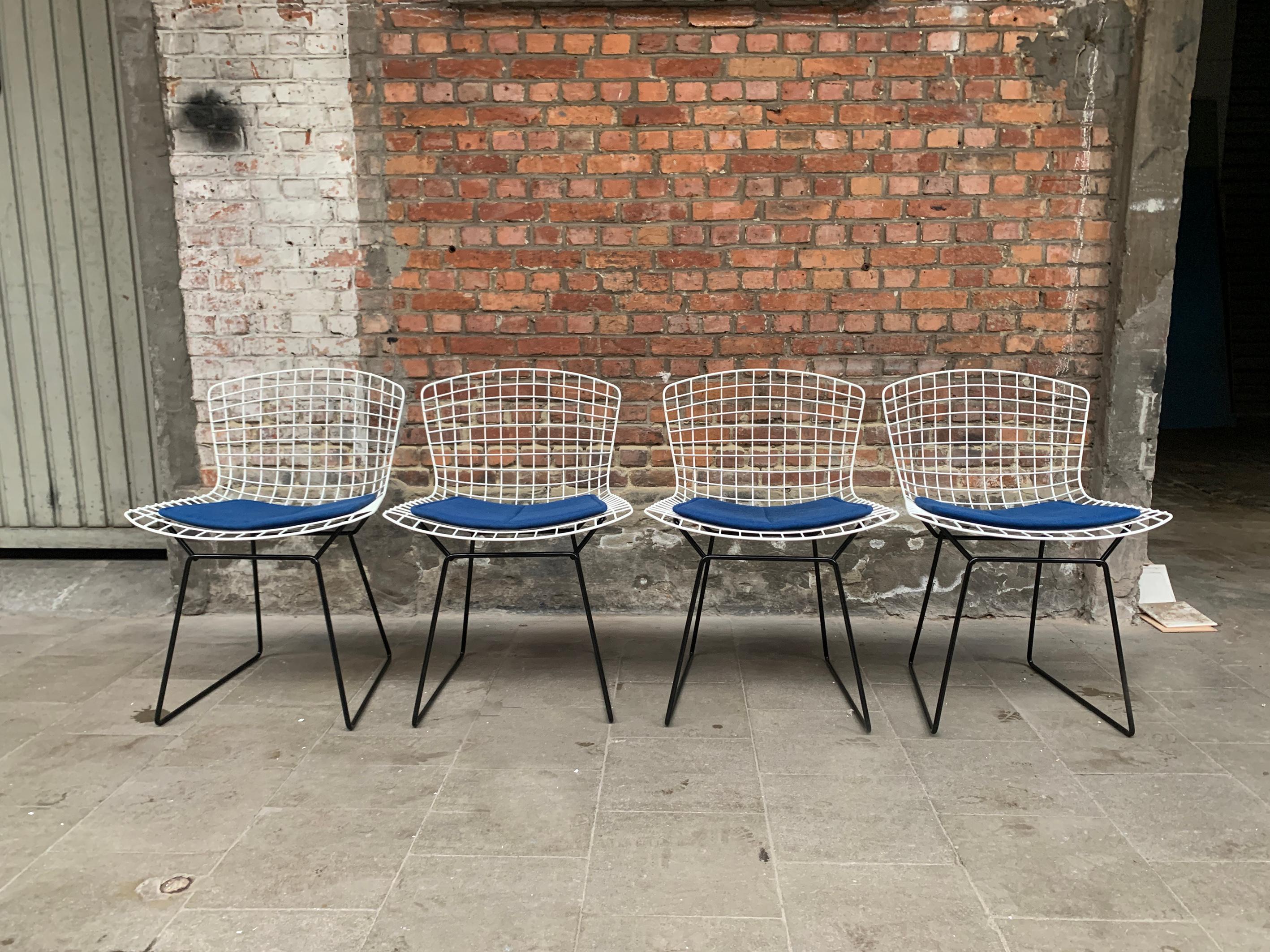 Set of four dining chairs model 420, design Harry Bertoia for Knoll International. 

Early chairs from the 50s/60s which have been restored. 

New powder-coating finish in black & white, conform to the original finish. The chairs will come with new