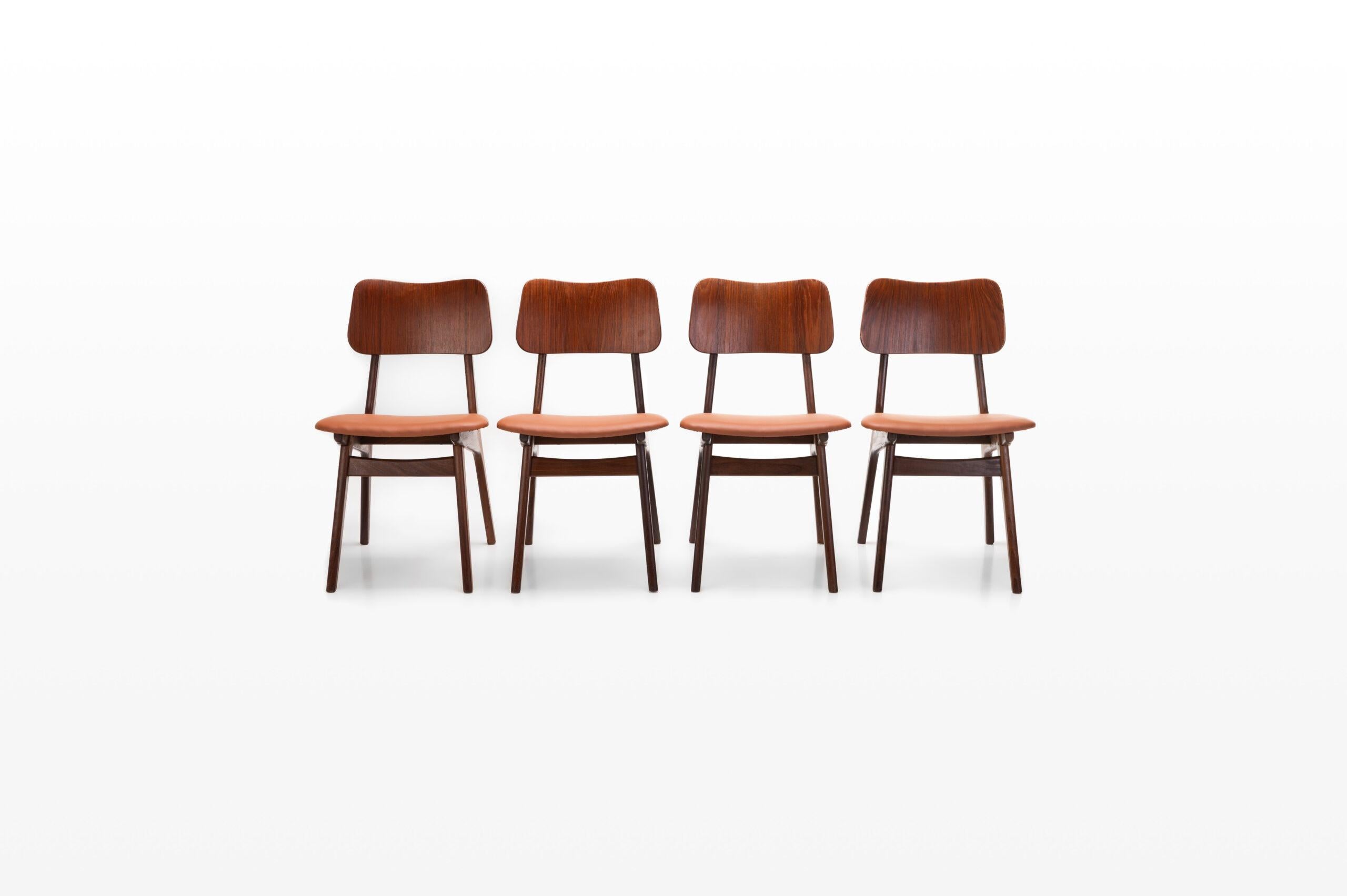 Set of four vintage dining chairs by Louis van Teeffelen for Wébé. The chairs have a teak frame and nice brass details. In very good condition and the seats are reupholstered in a cognac brown leatherette.
 